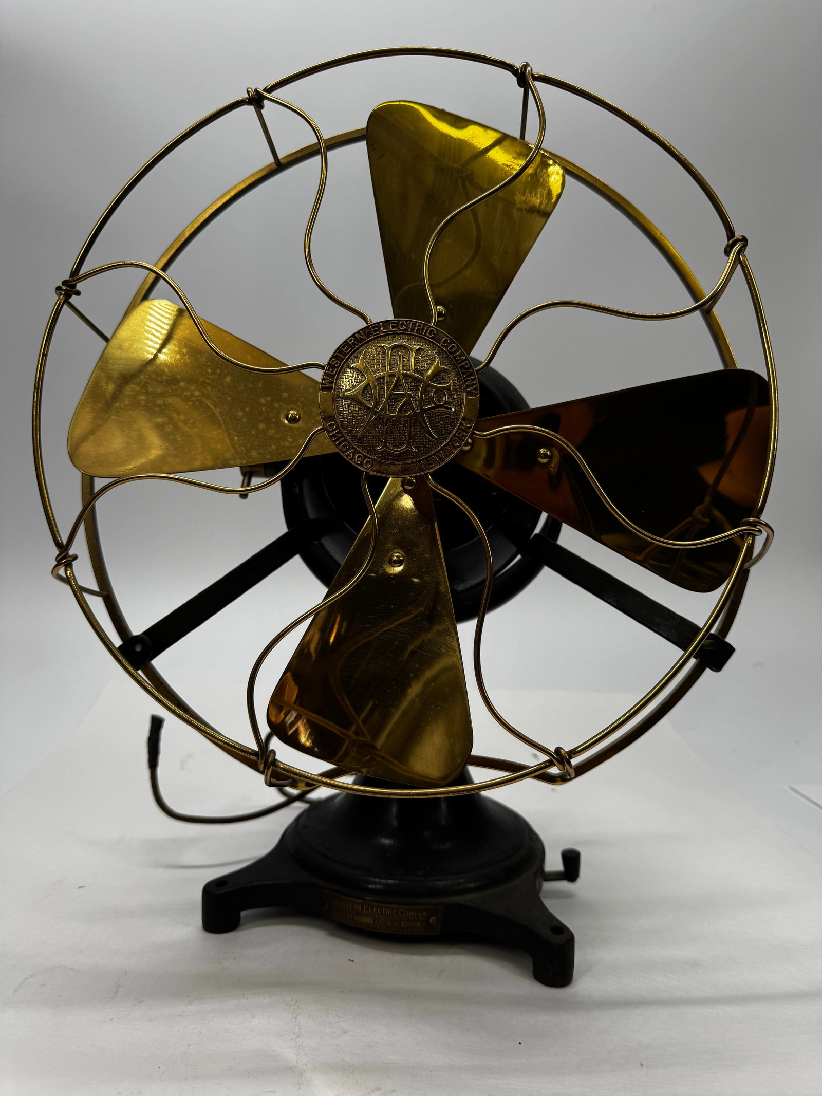 Antique Western Electric 12” Brass Blade Desk Fan Type U.D.10: Antique Western Electric Company desk fan, Type U.D.10, featuring a heavy cast iron base, four polished brass blades, and original S-wire brass cage with Western Electric center badge. Base tag is mar