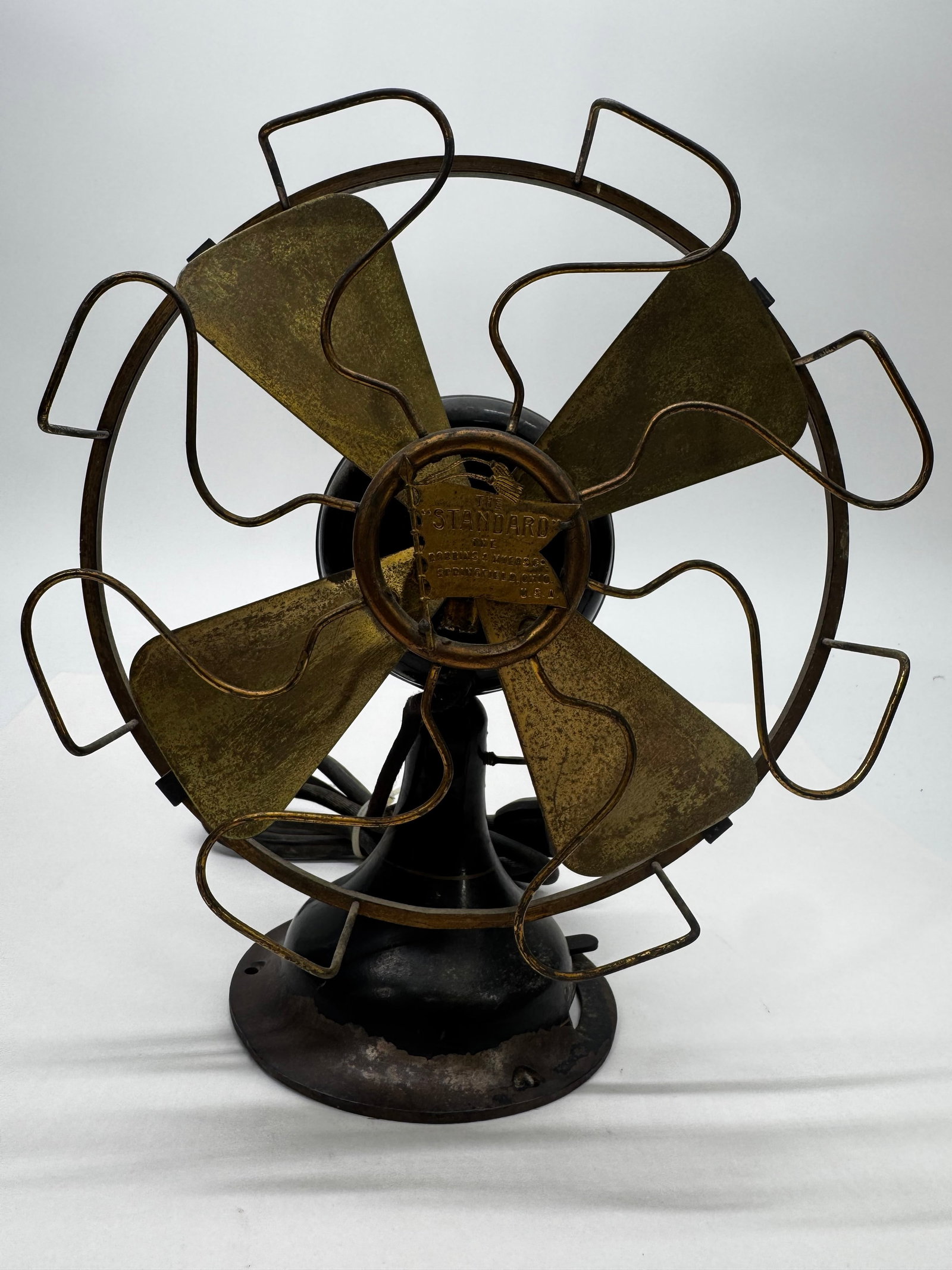 Antique Robbins & Myers “Standard” 12” Brass Blade Desk Fan List No. 1801: Antique Robbins & Myers “The Standard” desk fan manufactured in Springfield, Ohio. Features a heavy cast iron base, four brass blades, original flag-style center badge, and brass motor tag mar