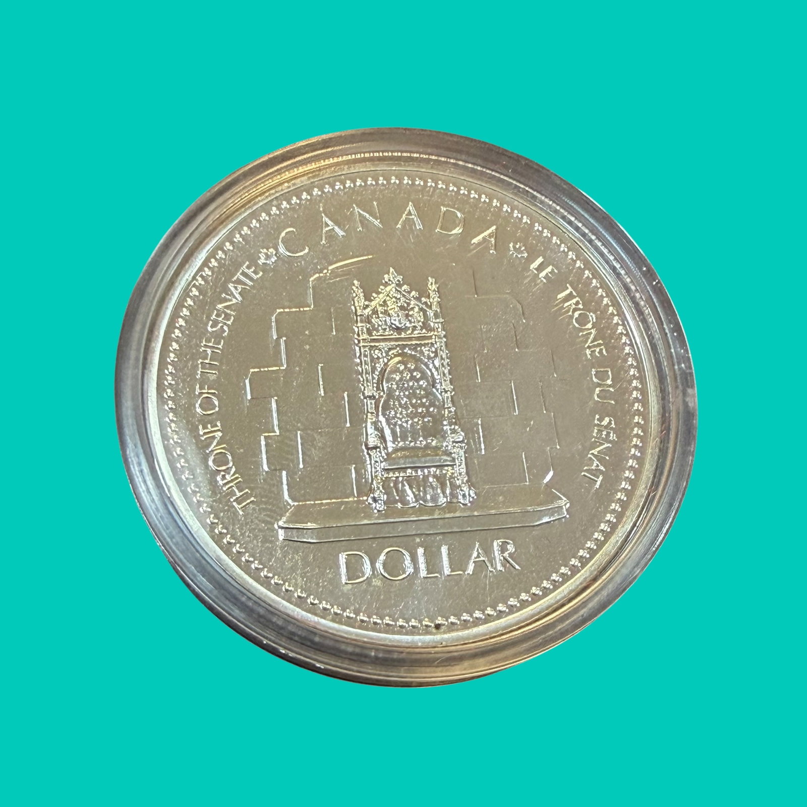 Silver Jubilee 1952 1977 Canada Dollar Silver Coin Uncirculated 23.33g: Description: Uncirculated coin, Elizabeth II Silver Jubilee 1952 - 1977. Throne of the Senate. Sealed in holder and with black frame. / Material: .5000 Silver. 36.07 mm dia. 23.33 grams./ Condition: G