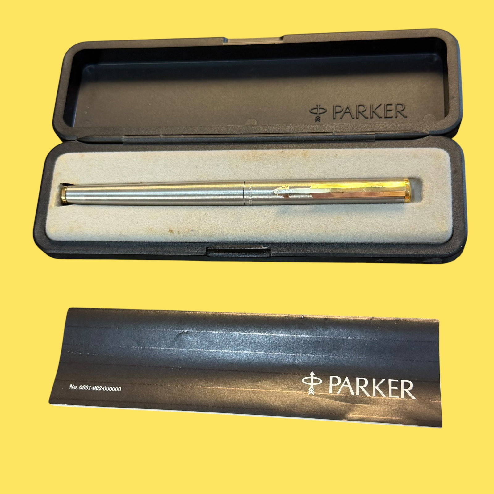 Vintage 1980s Stainless Steel Parker Arrow Flighter Roller Ball Point Pen in Original Box England: Description: Circa 1980s Stainless Steel Parker Arrow Flighter ball point pen in original black plastic box. Cap marked as being made in England. Also has original paper booklet. Gold tone metal accen