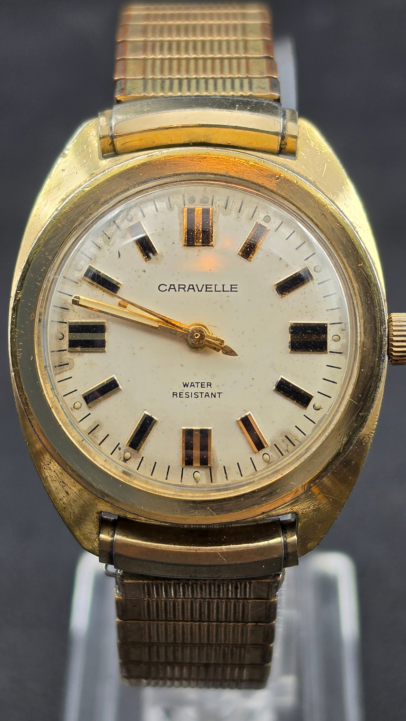 CARAVELLE 1970s Mens Gold Tone Tonneau Case Base Metal Mechanical Wristwatch Running 34mm: This is a vintage Caravelle wristwatch from the 1970s in its current condition. The dial reads Caravelle and Water Resistant, featuring a tonneau shaped gold tone case with black and gold striped bato