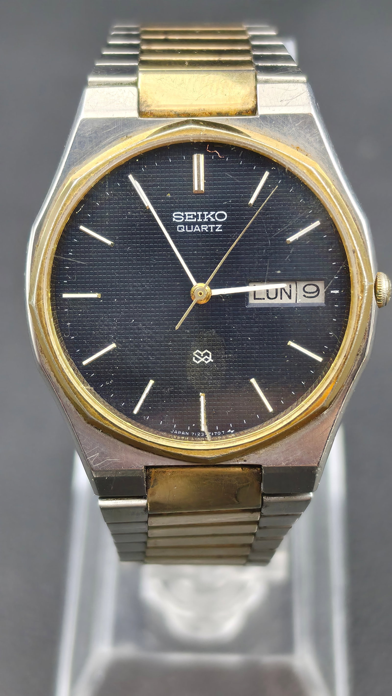 SEIKO QUARTZ 1980s Mens Two Tone Day Date Black Dial Stainless Steel Wristwatch Running 34mm: This is a vintage Seiko Quartz day date wristwatch from the 1980s in its current condition. The dial reads Seiko Quartz with the Seiko SQ logo, a black textured dial with baton hour markers, a day win