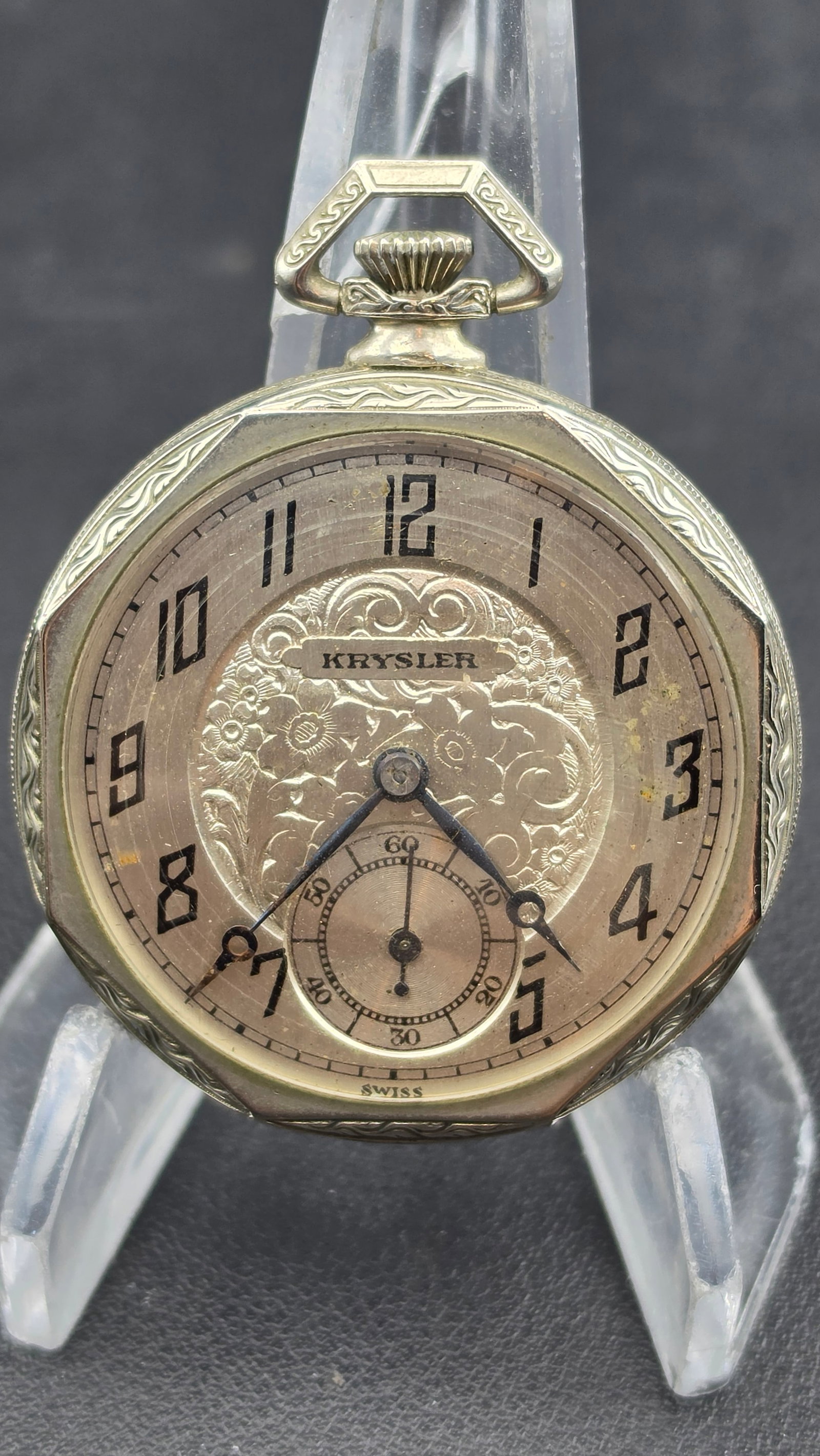 Art Deco Krysler Swiss Pocket Watch, Octagonal Case, Oris Movement, Running: This antique pocket watch has a 43.10mm octagonal case with an engine-turned Art Deco bezel design. The dial is signed "KRYSLER" with an ornate engraved floral medallion at center, Arabic numerals, an