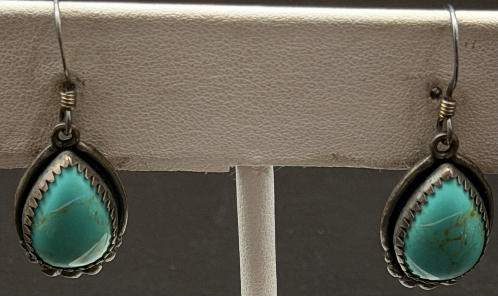 6g-Vintage Sterling Silver Turquoise Teardrop Dangle Earrings: Vintage sterling silver dangle earrings featuring natural teardrop-shaped turquoise cabochons set in sawtooth bezels. The handcrafted Southwestern design is accented with beadwork and suspended from s