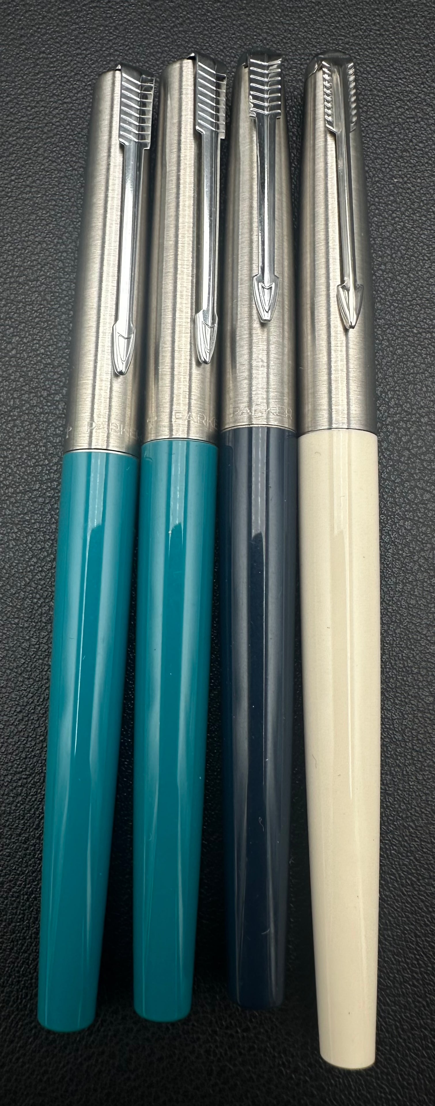 Vintage Parker 45 Fountain Pen Lot of 4 Stainless Steel Cap Assorted Colors: Lot of four vintage Parker 45 fountain pens featuring brushed stainless steel caps with the classic Parker arrow clips. Includes teal, turquoise, dark blue, and ivory barrels. All have stainless steel