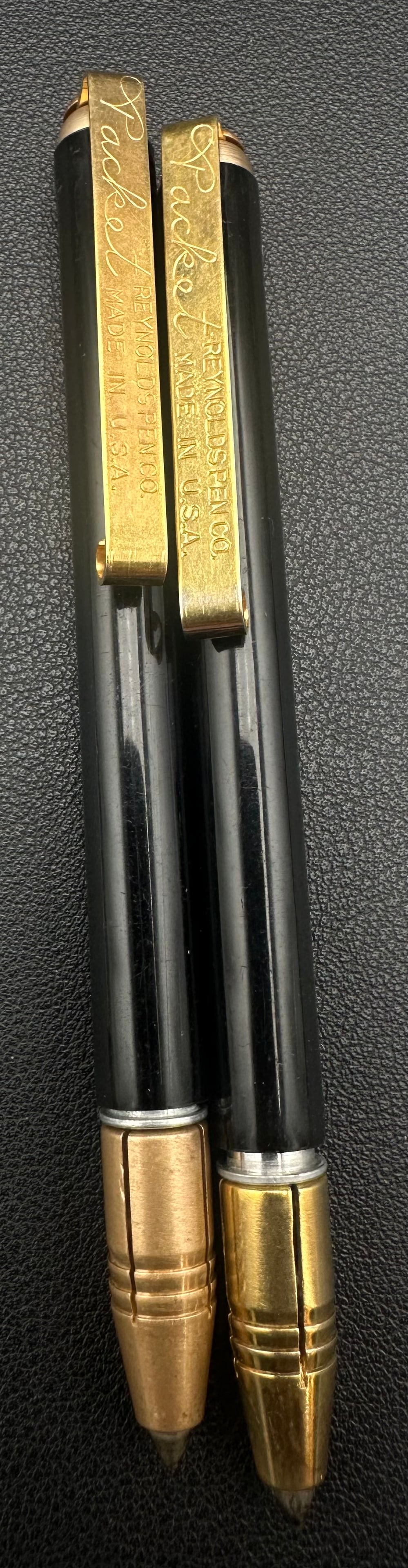 Vintage Reynolds Rocket Ballpoint Pen Lot of 2 Made in USA: Lot of two vintage Reynolds “Rocket” ballpoint pens made in the USA. Features black barrels with gold-tone caps, clips, and cone tips engraved “Reynolds Pen Co. Made in U.S.A.” One pen