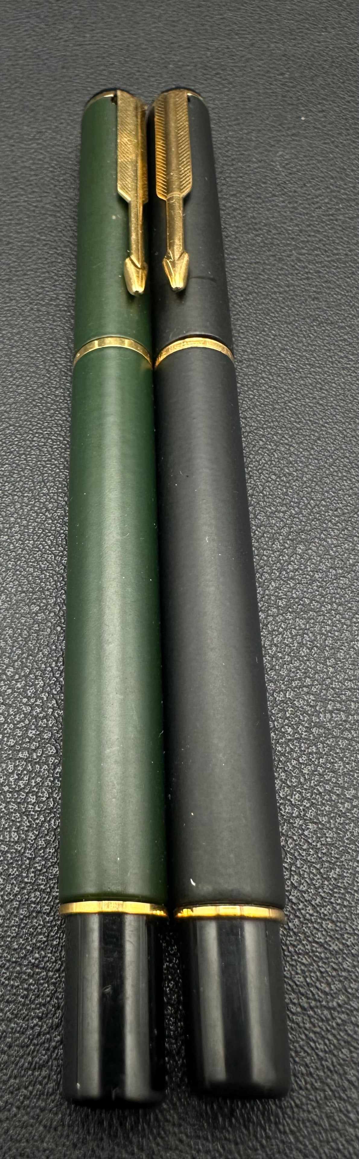 Vintage Parker 45 Fountain Pen & Pencil Set Gold Trim: Vintage Parker 45 writing set including a fountain pen with gold-tone Parker nib and matching mechanical pencil. Both feature matte dark green/black barrels with gold-filled arrow clips and trim. The 