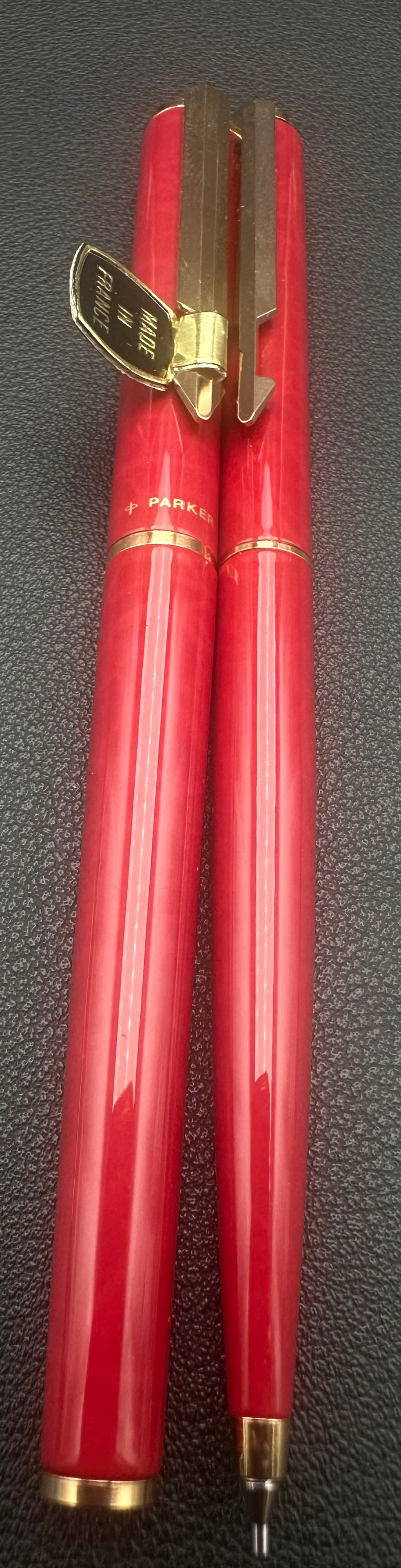 NOS Parker T1 Red Marble Fountain Pen Ballpoint Pencil Set France: New Old Stock (NOS) Parker T1 three-piece writing set in a rich red marbled lacquer finish with gold-tone trim. Made in France, this matching set includes a fountain pen with a Parker 14K gold nib, a 
