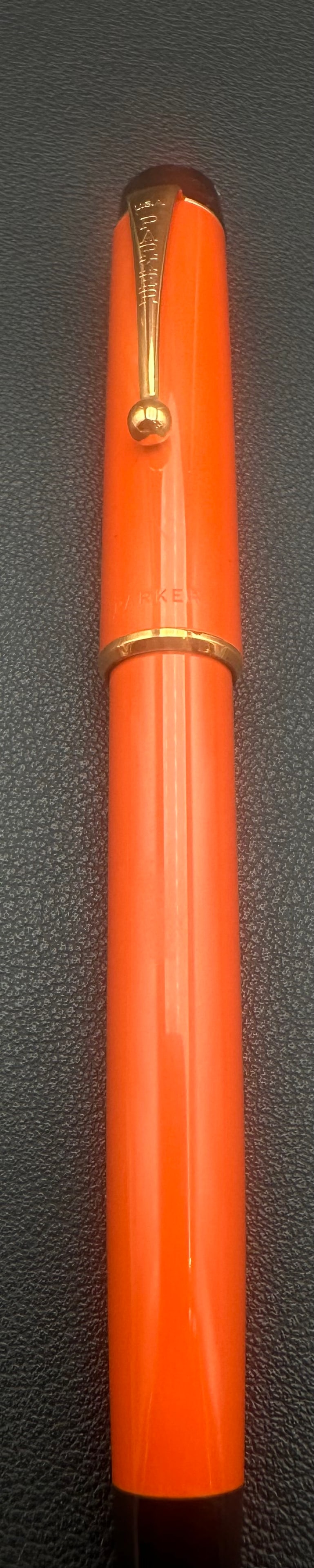 NOS Parker Duofold Orange Rollerball Pen Black Trim USA: New Old Stock (NOS) Parker Duofold rollerball pen in bright orange resin with black trim and gold-tone clip, made in the USA. Features the classic Duofold design with a capped rollerball writing syste