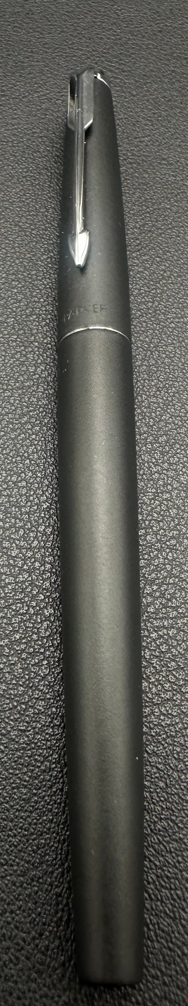 Vintage Parker Vector Matte Black Rollerball Pen Q1 England: Vintage Parker Vector rollerball pen in a matte black finish with chrome trim and the classic Parker arrow clip. Barrel is date coded Q1 and marked “Made in England.” Shows light signs of use 