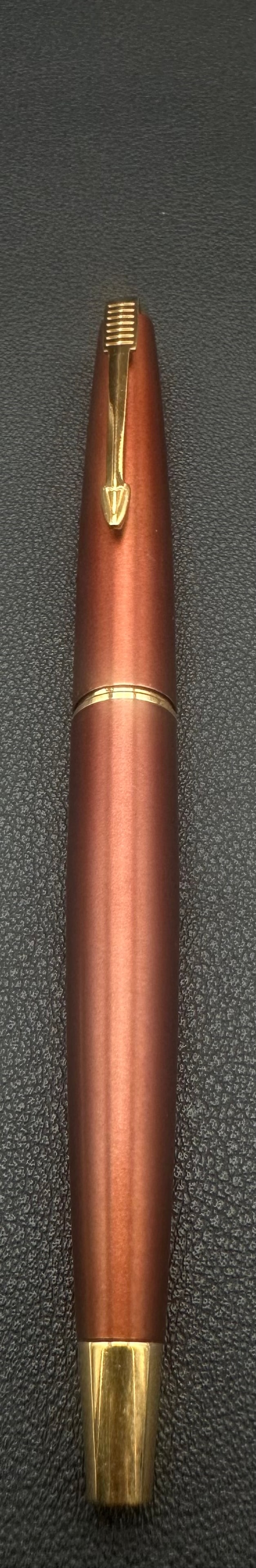 Parker 45 Flighter GT Fountain Pen Brushed Burgundy Gold Trim: Vintage Parker 45 Coronet fountain pen, circa 1960s–1970s, featuring a brushed metallic brown finish with gold-plated trim and the iconic Parker arrow clip. The pen has the classic tapered Coronet d
