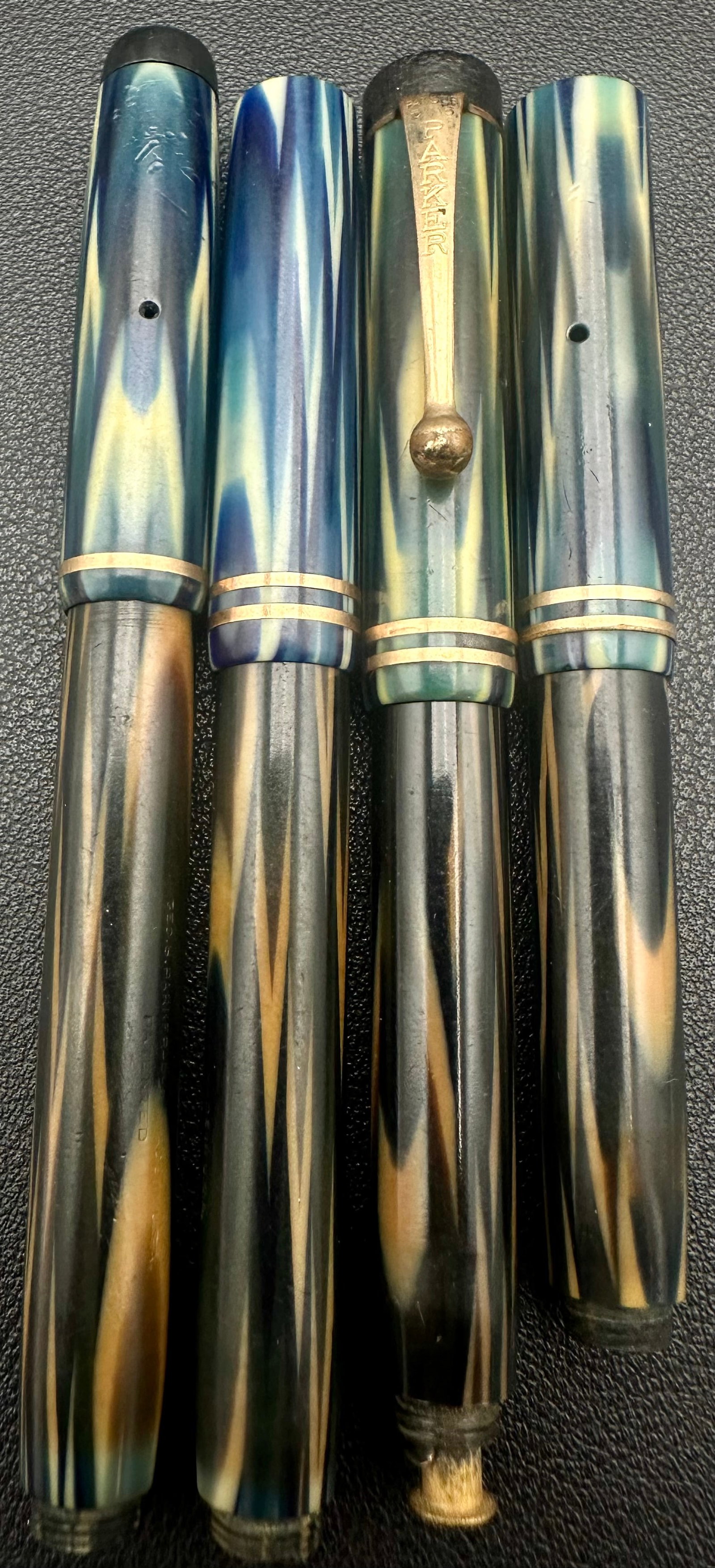 Vintage Parker Duofold Jr. Fountain Pen Parts Lot Blue Marble: Lot of four vintage Parker Duofold Jr. blue marbled fountain pen parts, including barrels and caps in blue/green pearlized celluloid. One cap retains its original Parker clip, while the remaining piec