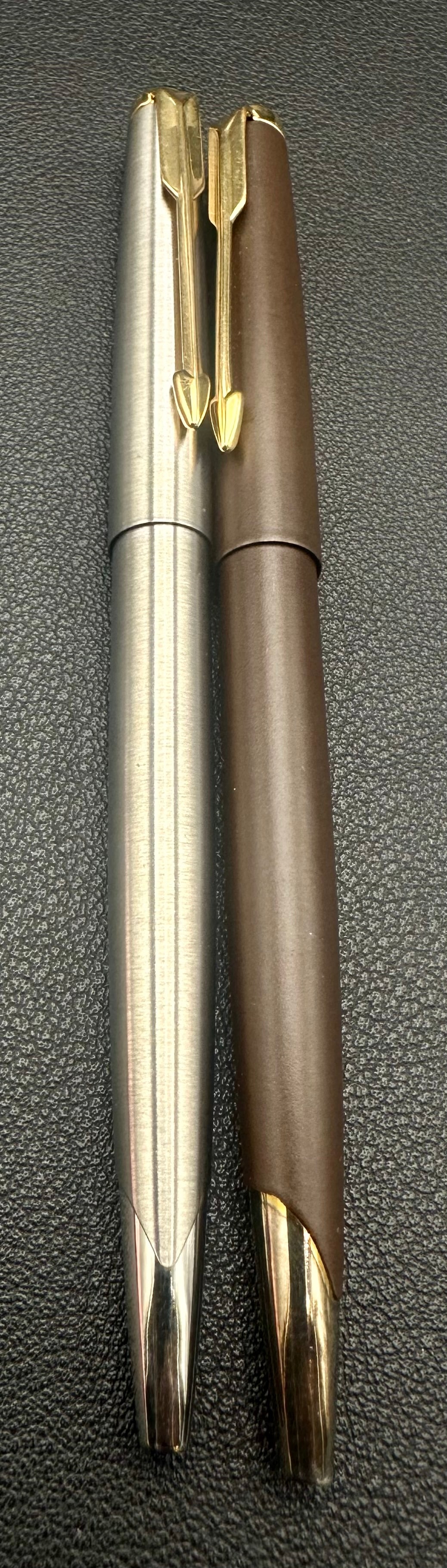 Pair Parker 45 Ballpoint Pens Brushed Steel & Brown Matte: Lot of two vintage Parker 45 twist ballpoint pens. Includes one brushed stainless steel finish and one matte brown finish, both with gold-tone arrow clips and chrome nose cones. Both retain their orig