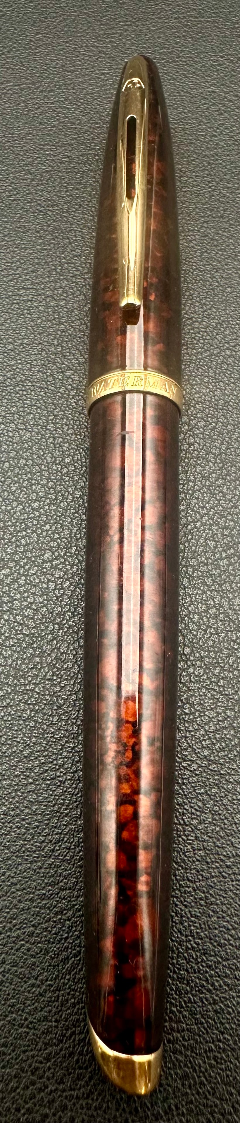 Waterman Carène Marine Amber Brown Marbled Lacquer Gold Trim Pen France: Elegant Waterman Carène pen in the sought-after Marine Amber finish, featuring a rich brown marbled lacquer barrel with gold-plated trim. The signature streamlined design is inspired by luxury yacht 