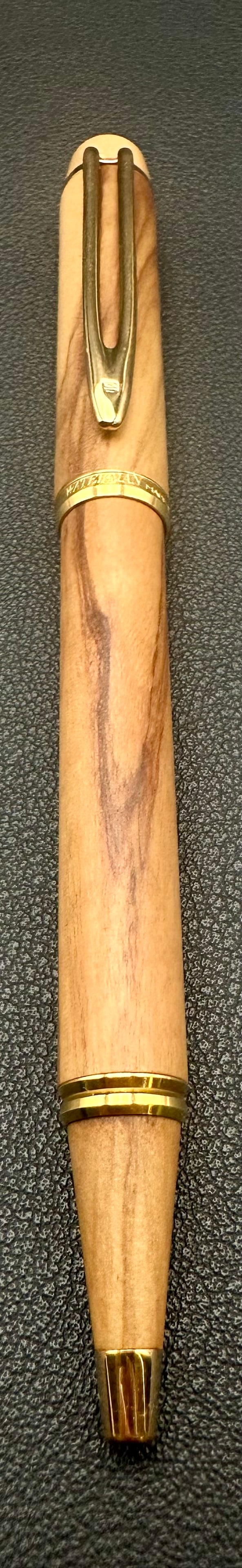 Waterman Olivewood Ballpoint Pen Gold Trim Made in France: Genuine Waterman twist-action ballpoint pen crafted with a beautiful natural olivewood barrel featuring distinctive grain patterns. Finished with gold-plated trim, Waterman clip, and center band engra