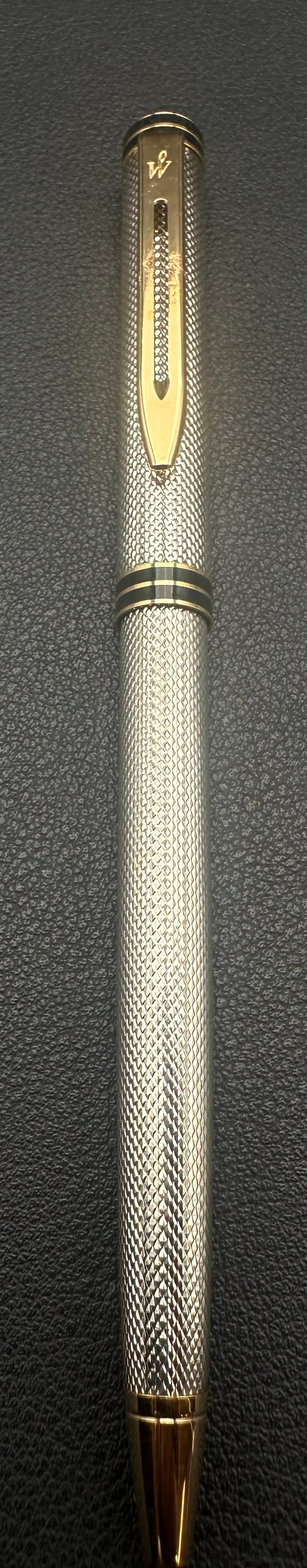 Waterman Gentleman Silver Plated Guilloché Ballpoint Pen Made in France: Vintage Waterman Gentleman twist-action ballpoint pen featuring a silver-plated engine-turned guilloché finish with gold-plated trim and black lacquer accent bands. Made in France, this elegant writi