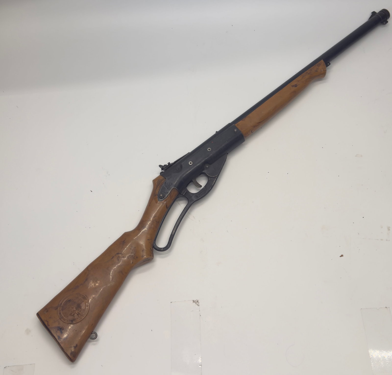 Vintage Daisy Lever Action BB Air Rifle w/ Air Rifleman Medallion: Vintage Daisy lever-action BB air rifle featuring a hardwood stock with the original Daisy Air Rifleman safety medallion, blued steel barrel and receiver, and tubular magazine. Shows moderate finish w