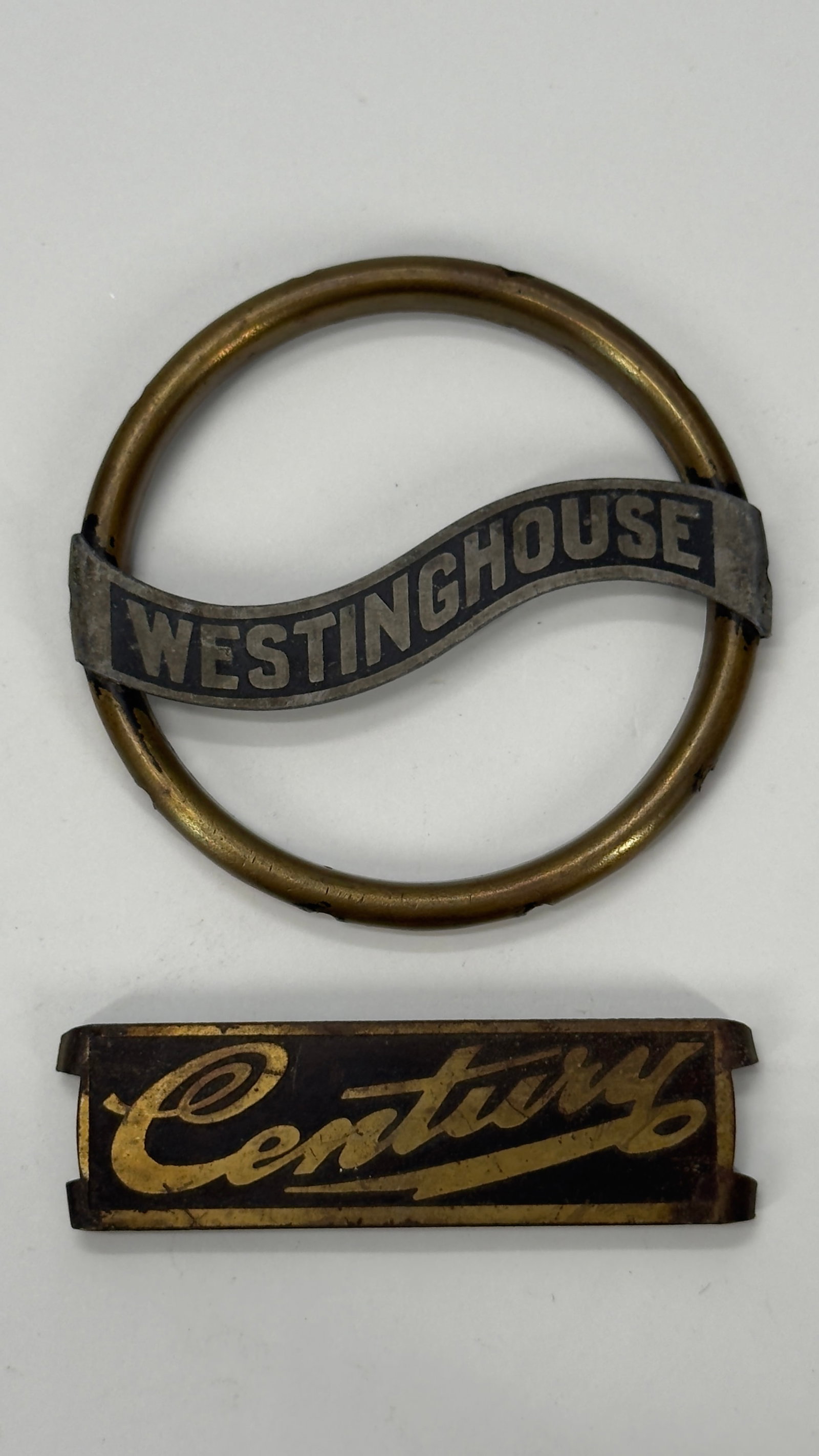Vintage Westinghouse & Century Fan Motor Nameplates Lot: Lot of two vintage metal nameplates including a Westinghouse circular fan badge and a Century script nameplate. Originally used on electric fans, motors, or other electrical equipment, dating from the