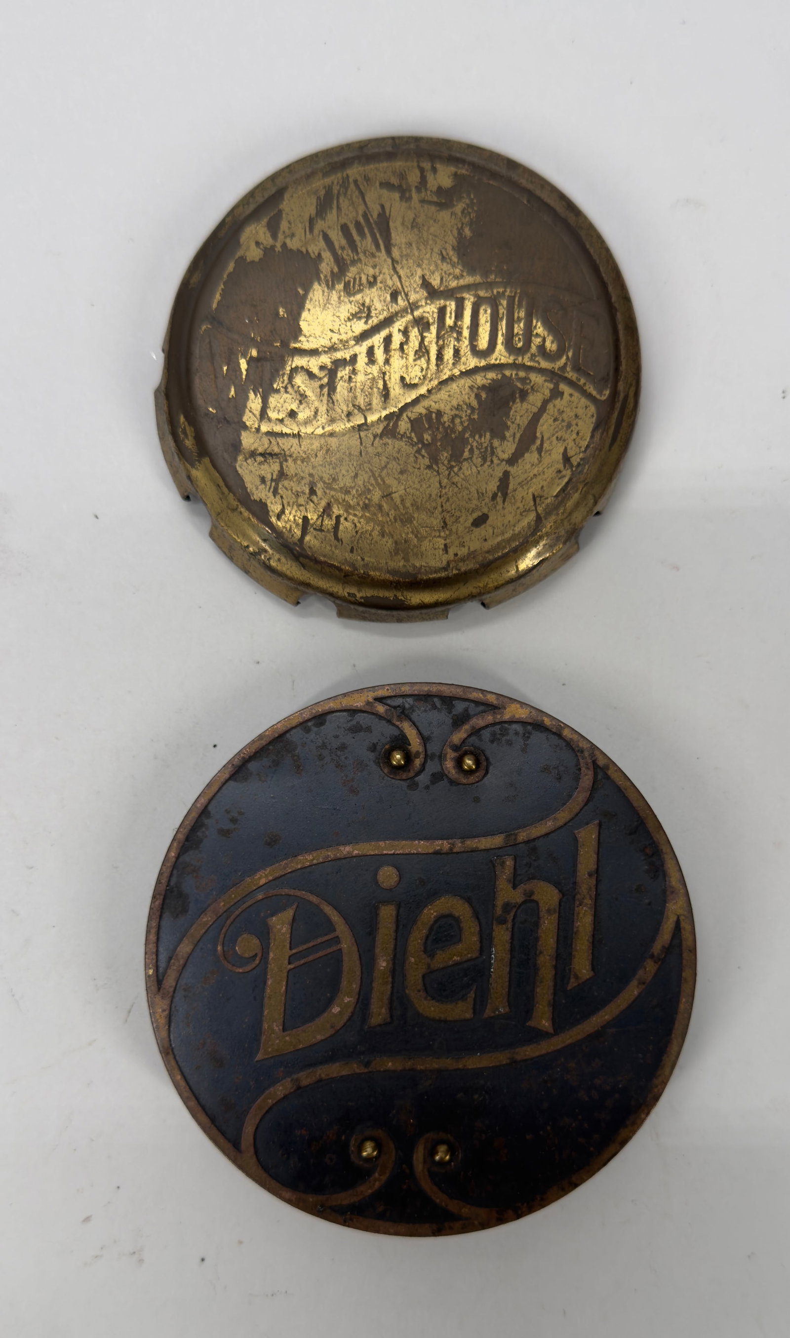 Vintage Westinghouse & Diehl Fan Badges Lot: Lot of two original vintage electric fan badges including a Westinghouse brass motor cap and a Diehl black-and-gold metal nameplate. Both date to the early 20th century and retain their original finis