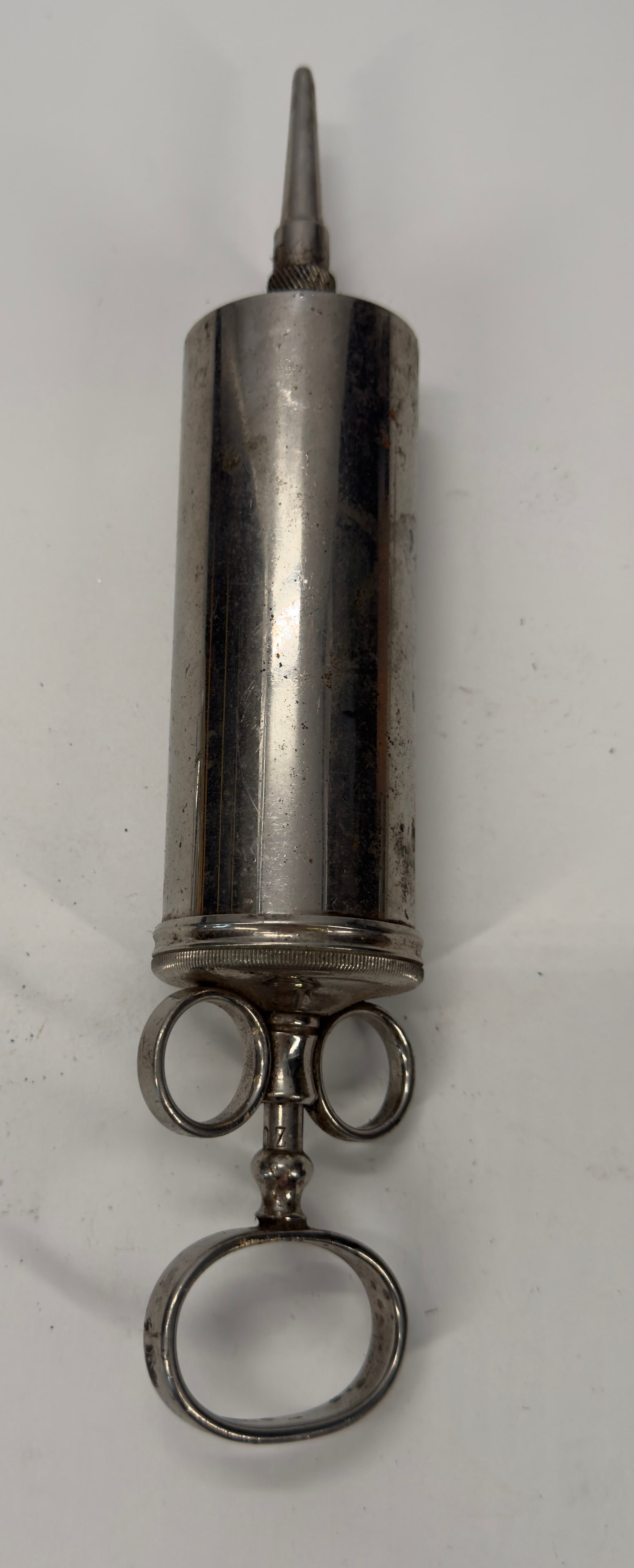 Antique Arnco Embalming Syringe w/ Screw-On Cannula c. 1900–1910: Original Arnco embalming syringe dating to the early 20th century. Features a nickel-plated metal barrel, graduated piston with finger-ring handle, and original screw-on metal cannula. Used by underta