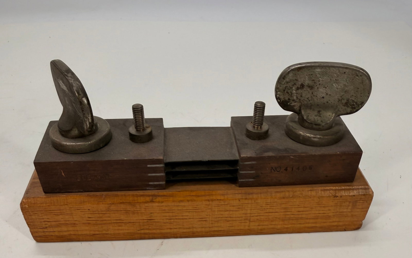 Vintage Adjustable Machinist V-Block Holding Fixture: Vintage adjustable machinist’s V-block holding fixture made of hardened steel with two swivel clamping pads and an adjustable center section for holding round stock or shafts. Mounted on a hardwood