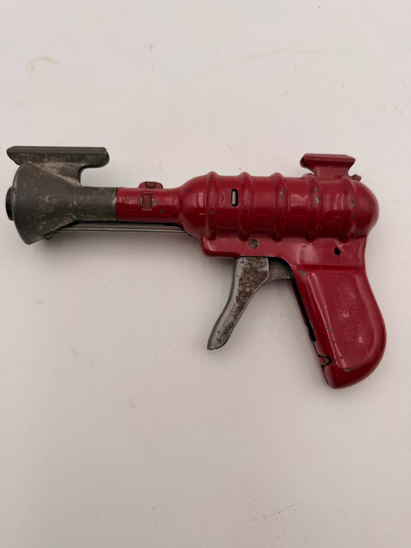 All Metal Products “33 Repeater” Ray Gun Toy c.1935: Vintage All Metal Products Co. “33 Repeater” pressed-steel ray gun, manufactured in Wyandotte, Michigan, circa 1935–1941. Finished in red with a gray flared muzzle, this classic science