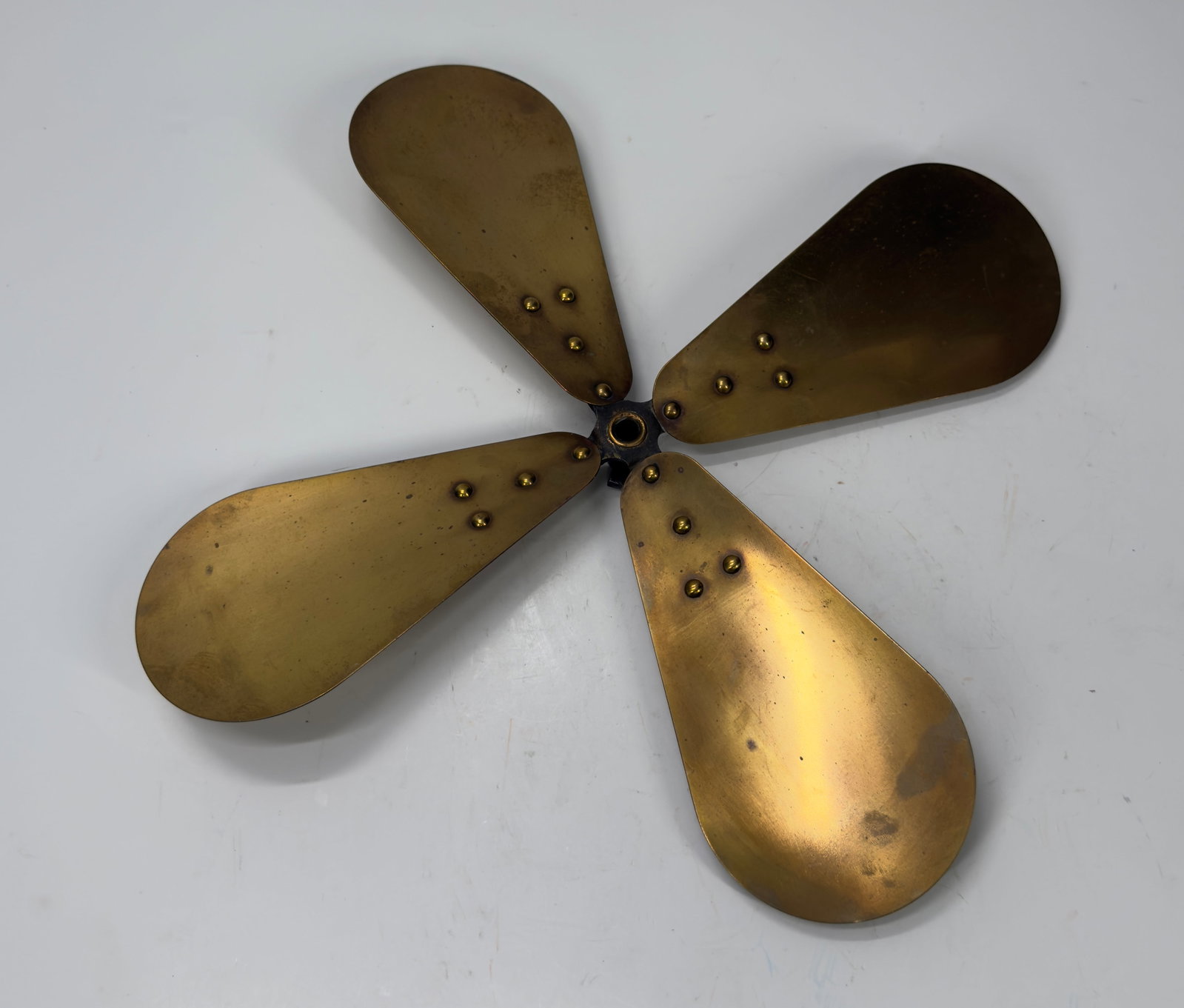 Antique 4-Blade Brass Electric Fan Blade Assembly c.1900–1925: Original antique 4-blade brass fan blade assembly with cast iron hub and set screw. Features four riveted brass blades with an attractive aged patina, suitable for restoration of an early electric des