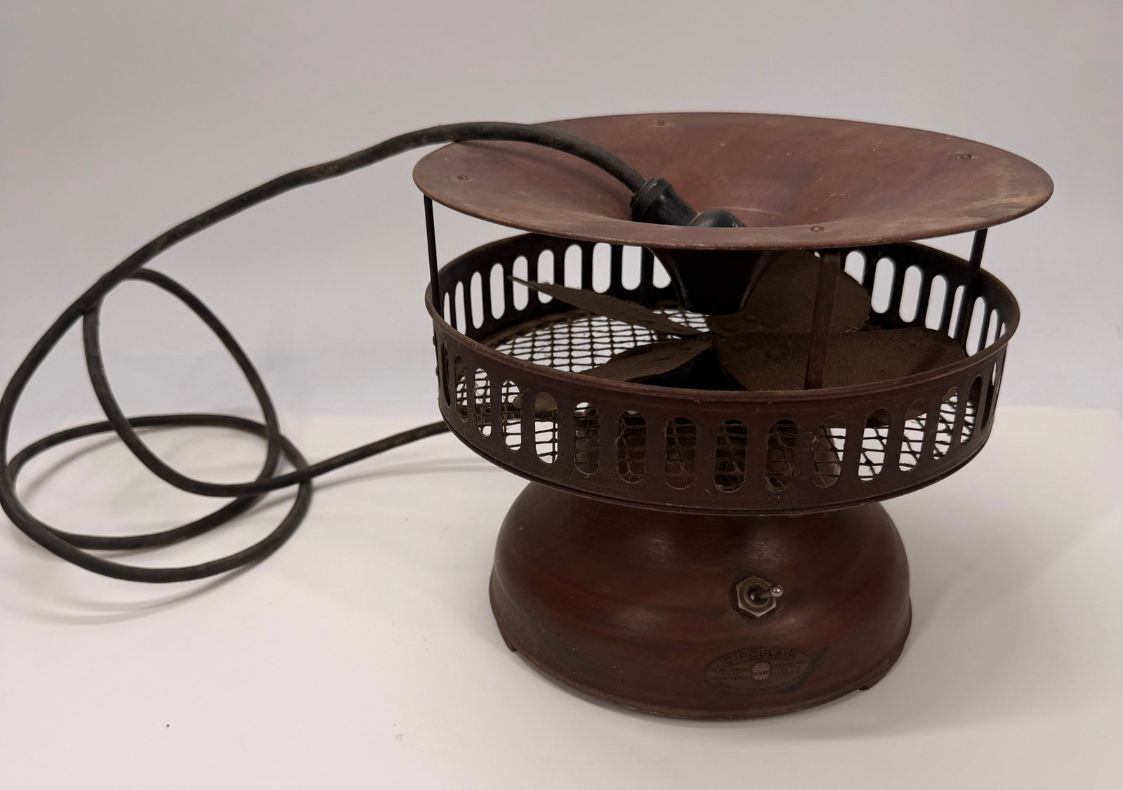 1930s Circulair Art Deco Electric Table Fan: Vintage 1930s Circulair electric table fan manufactured by the Electro Mfg. Co. of America. Features a steel body with its original copper-colored finish, distinctive open-grid cage, and four-blade me