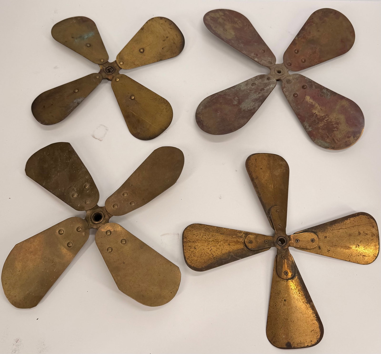 Lot of 4 Vintage Brass Fan Blade Assemblies: This lot includes four vintage brass fan blade assemblies from early electric fans. Each features a classic 4-blade design with a central hub and retains its original aged finish. These original fan c