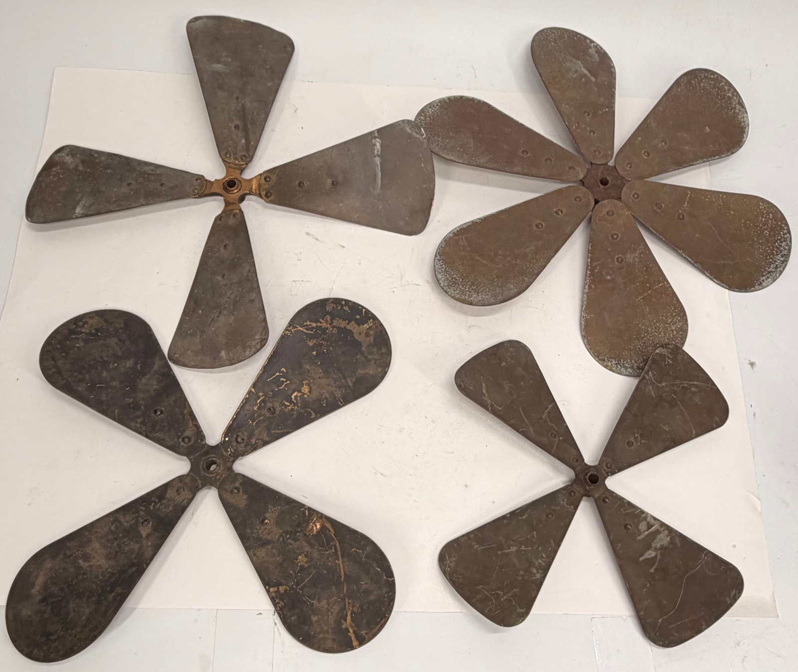 Lot of 4 Vintage Metal Fan Blade Assemblies: This lot includes four vintage metal fan blade assemblies from early electric fans. Featuring a rustic, weathered finish with authentic age-related patina, these original fan components are ideal for 