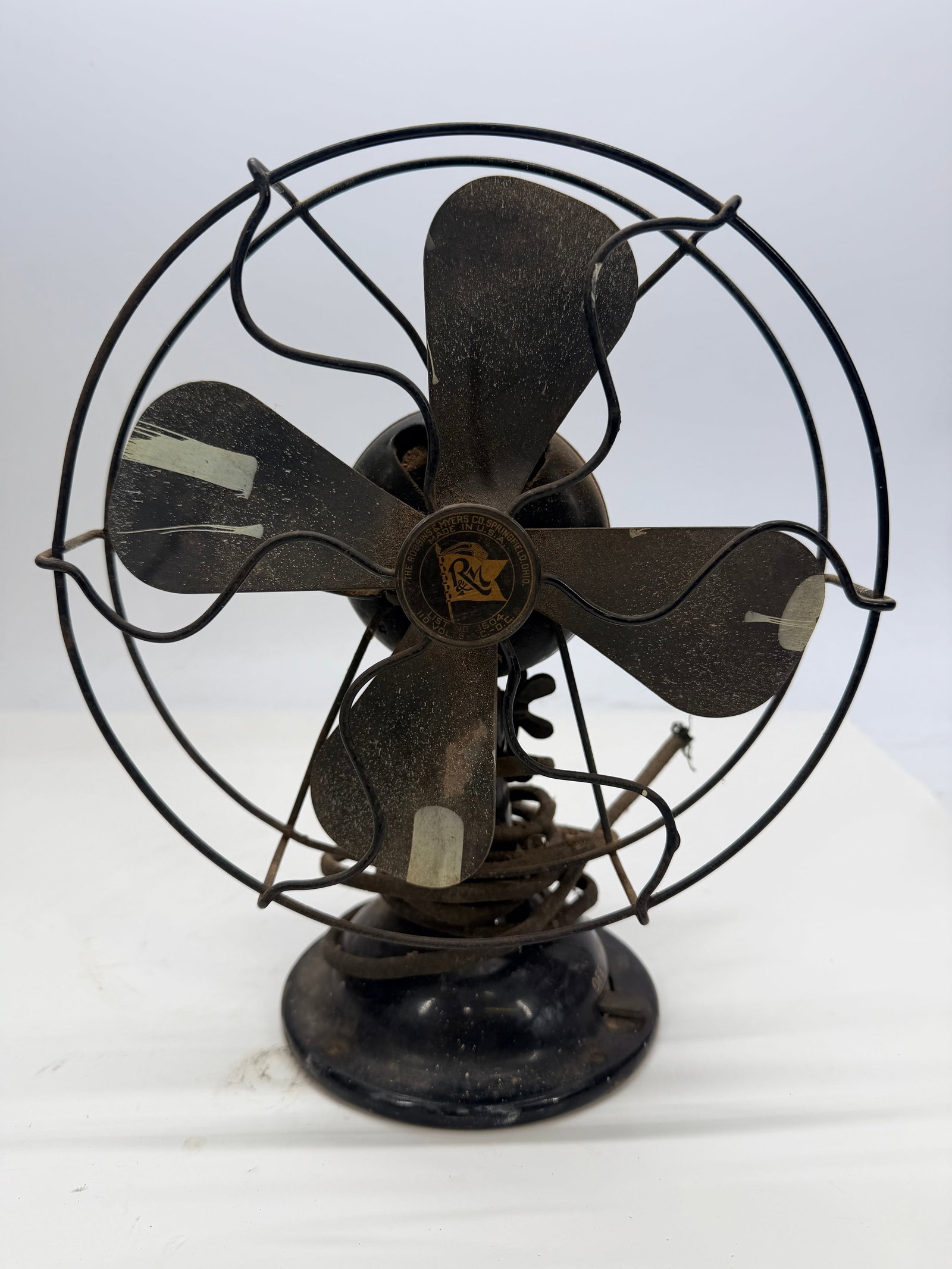 Electric fan by The Robbins & Myers Co: A vintage electric fan by The Robbins & Myers Co. of Springfield, Ohio (List No. 3504, 110 Volts, AC-DC), made in the U.S.A. It has a four-blade metal propeller housed in a round wire cage, mounted on