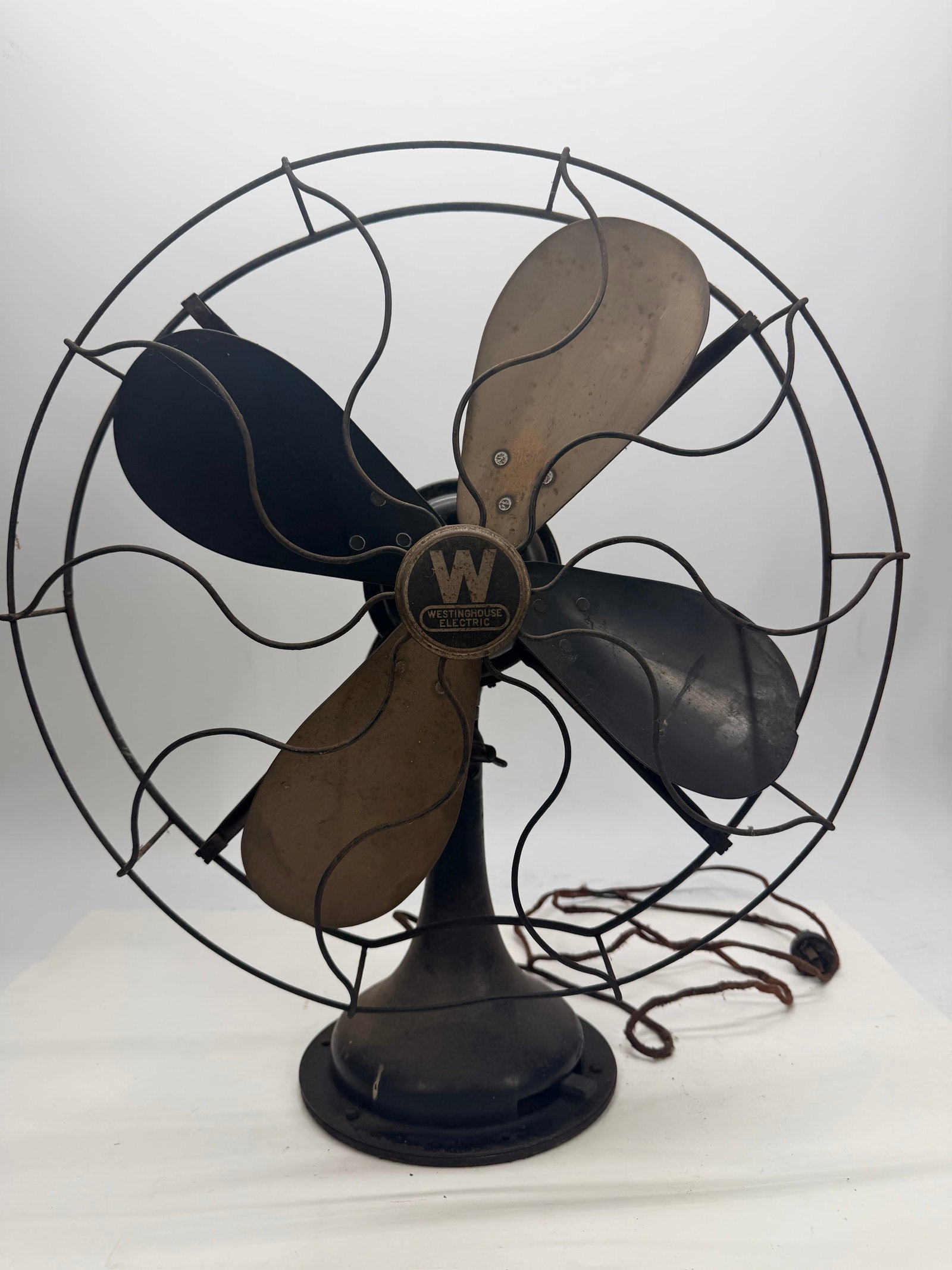 Westinghouse Electric Fan: This four-blade fan was made by Westinghouse Electric & Mfg. Co. of Pittsburgh, PA, with the iconic “W” Westinghouse badge on the hub. The blades are a mix of brass and painted black finish, m