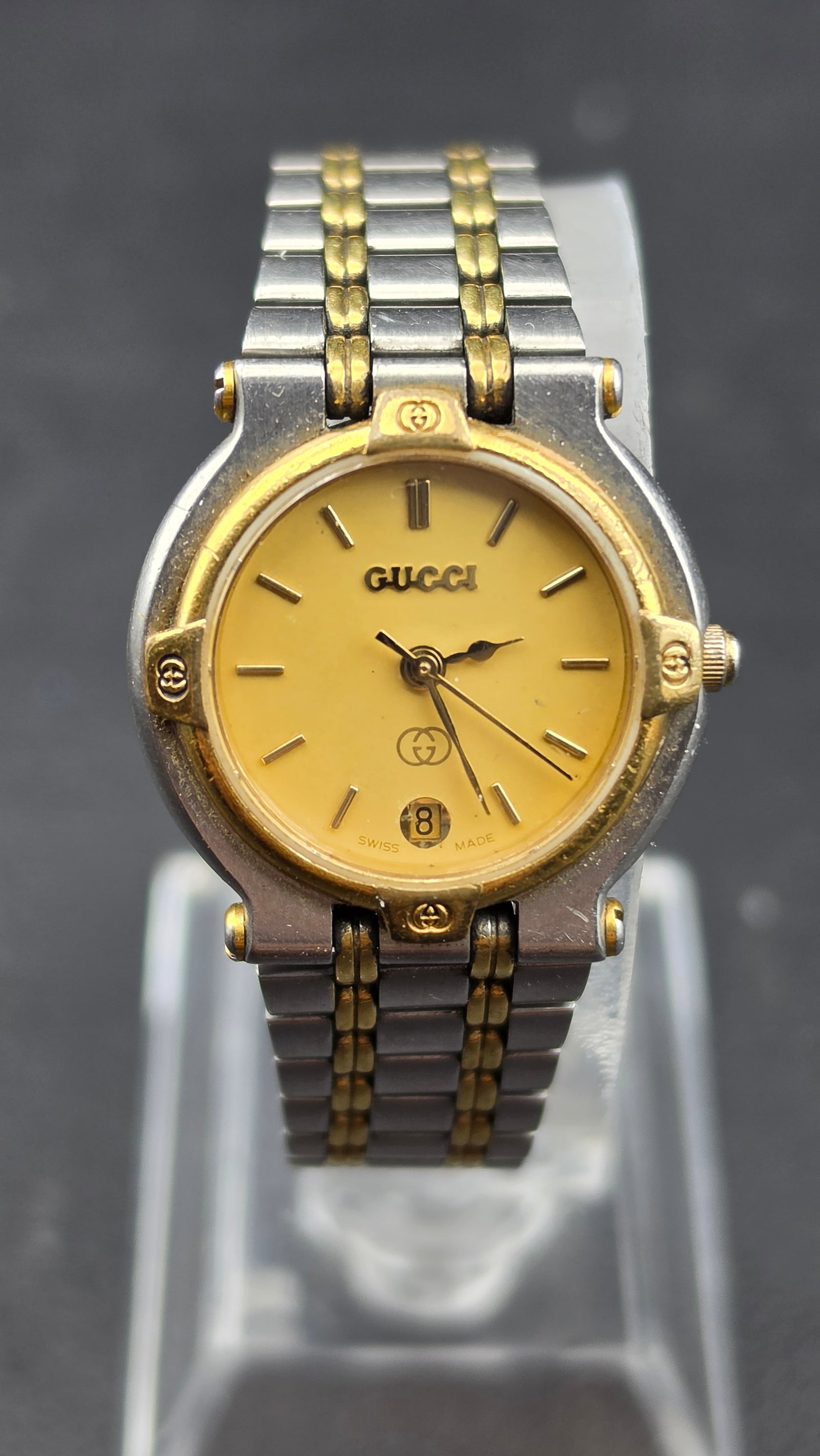 Gucci 9000L Ladies Two-Tone Stainless Steel and Gold Swiss Quartz Watch, 1990s, GG Logo Dial, Gucci: ladies Gucci model 9000L wristwatch in two-tone stainless steel and gold-tone finish. The ivory/cream dial is signed GUCCI below the 12 o'clock marker and features the interlocking GG logo above 6 o'c
