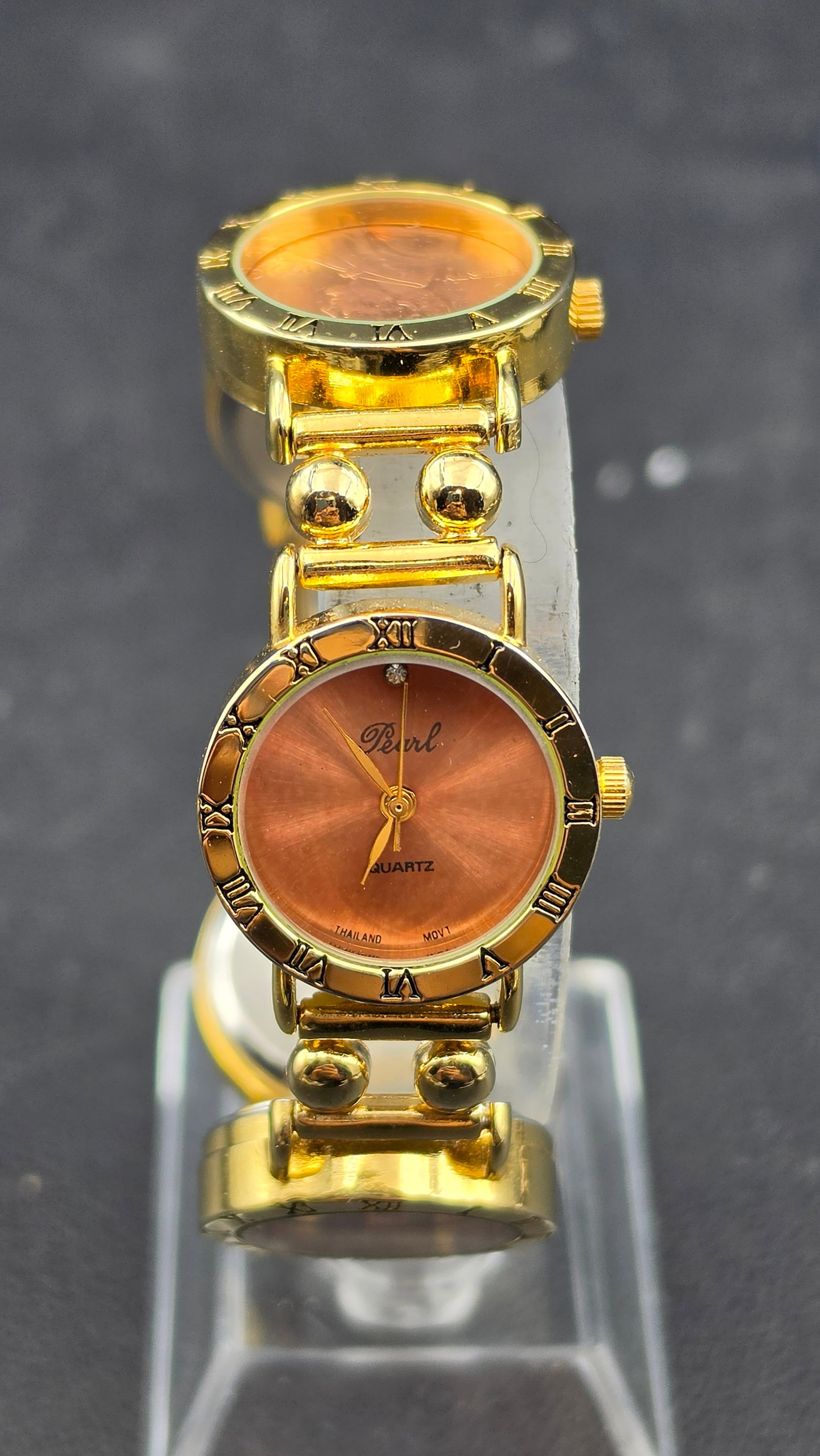 Pearl Quartz Gold Tone Bracelet Watch with Lincoln Penny Coin Link Accents New Battery: This is a novelty gold tone bracelet watch signed Pearl, Quartz, Thailand Movt. The working watch head has a round brown dial with a Roman numeral bezel and a small stone accent at 12. The bracelet ba