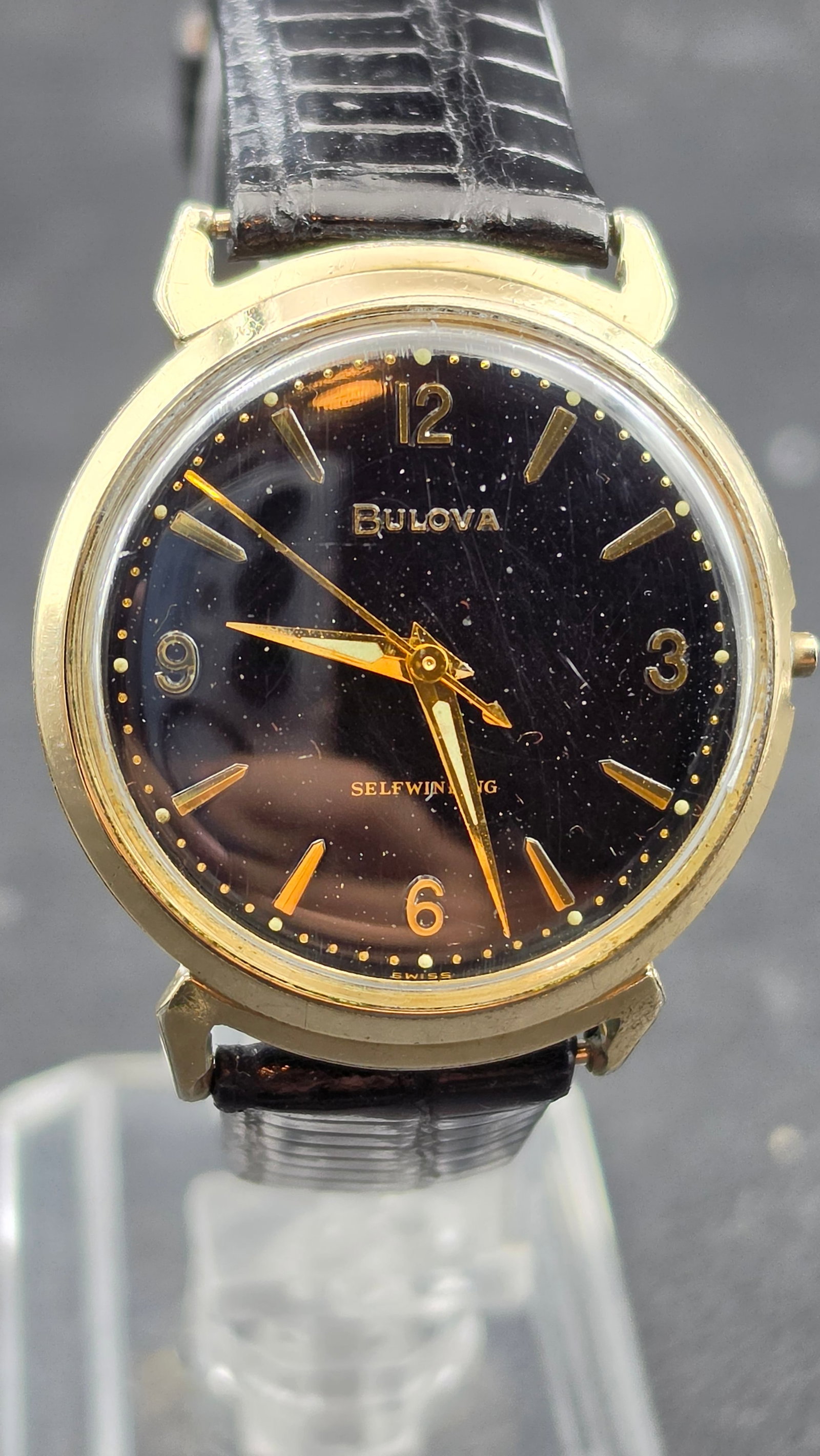 1962 Bulova Selfwinding Mens Watch 17 Jewels 11AFAC 10KT RGP Bezel Black Dial: This is a vintage Bulova Selfwinding automatic wristwatch dating to 1962. The black dial reads Bulova, Selfwinding, Swiss, with applied gold tone Arabic numerals at 12, 3, 6, and 9, gold baton markers