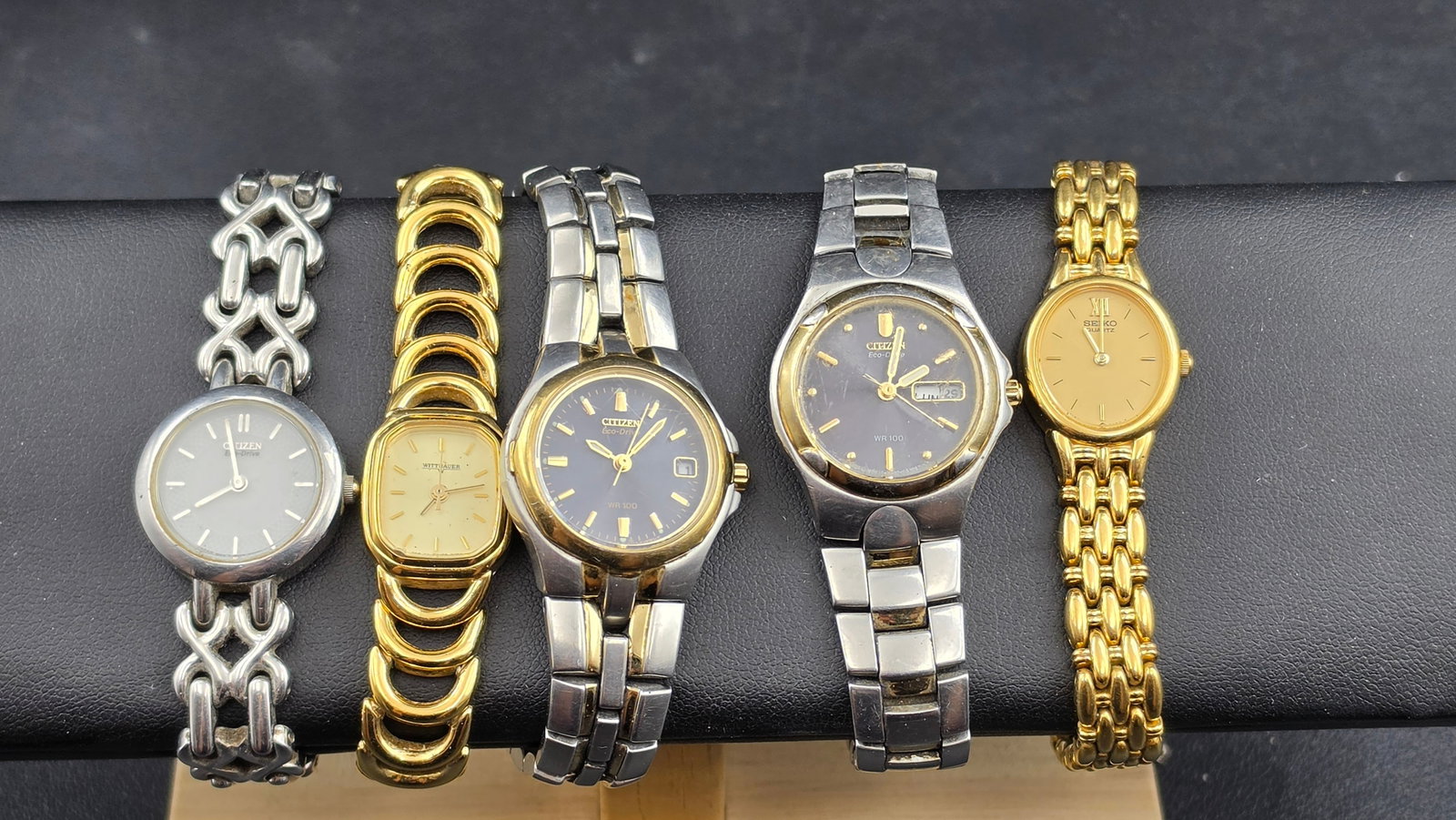 Lot of 5 Ladies Watches Citizen Eco-Drive Wittnauer Seiko Two Tone and Gold Tone: This lot includes five ladies quartz wristwatches. Three are Citizen Eco-Drive models: one with a round stainless steel case, white dial, and an ornate stainless steel X-link bracelet, case back marke
