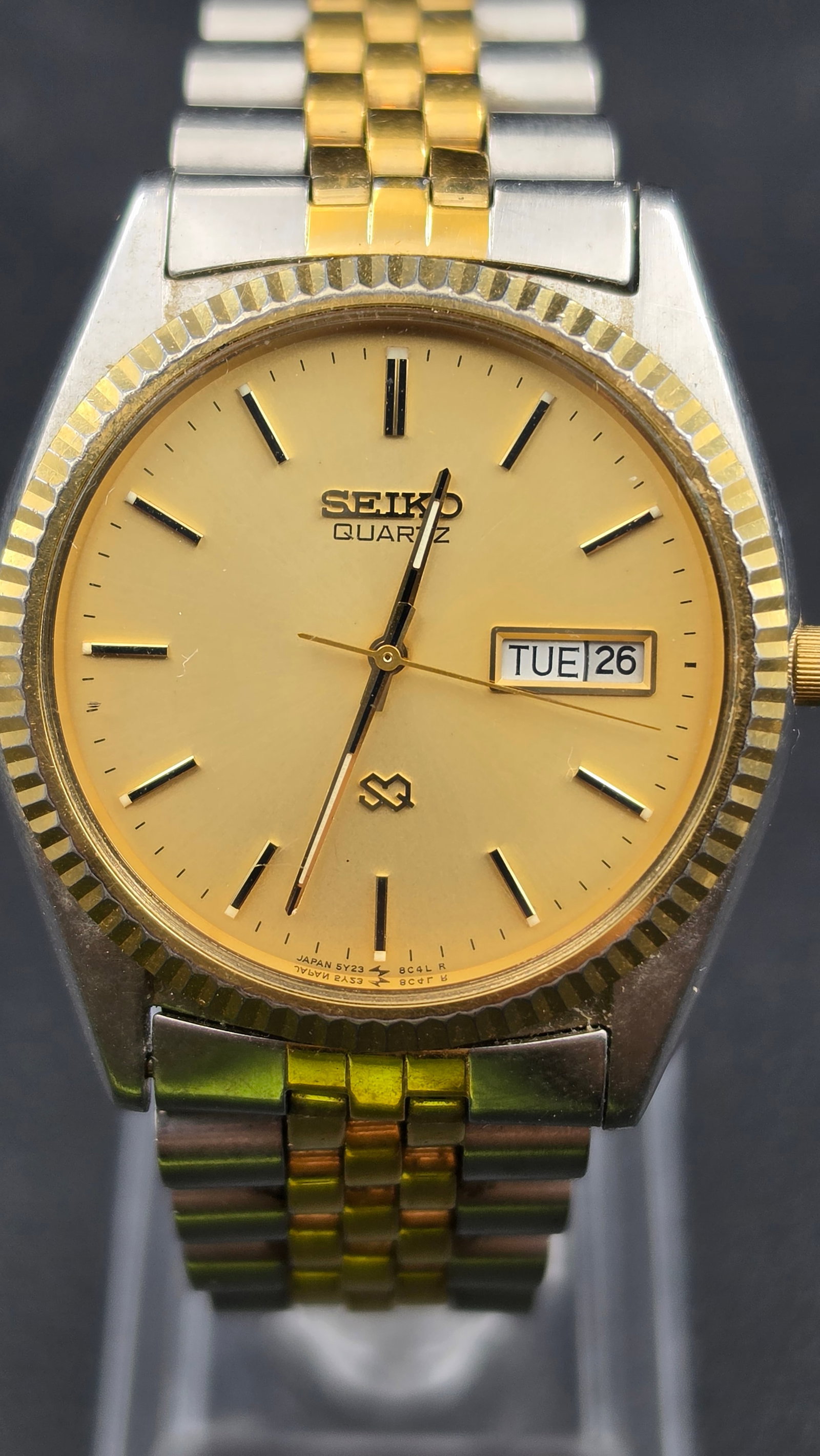 1989 Seiko SQ Quartz Day Date Fluted Bezel Two Tone Watch, Ref 5Y23-8A60, Jubilee Bracelet: This is a men's Seiko SQ Quartz dress watch in a two tone stainless steel and gold tone case, measuring approximately 36mm (measured with digital calipers). The gold tone dial is signed Seiko Quartz, 