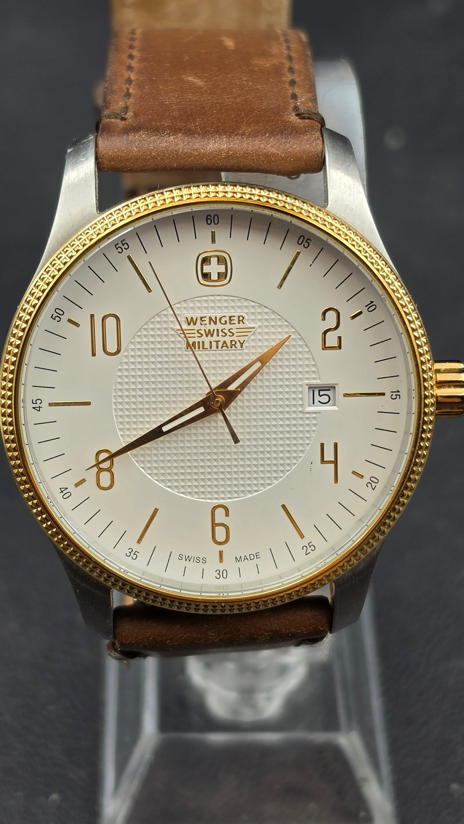 Wenger Swiss Military Two Tone Quartz Watch, White Dial, Date, 42mm, Leather Strap, 2010s: This is a men's Wenger Swiss Military watch in a stainless steel case with a gold tone bezel and crown, measuring approximately 42mm (measured with digital calipers). The white dial is signed Wenger S