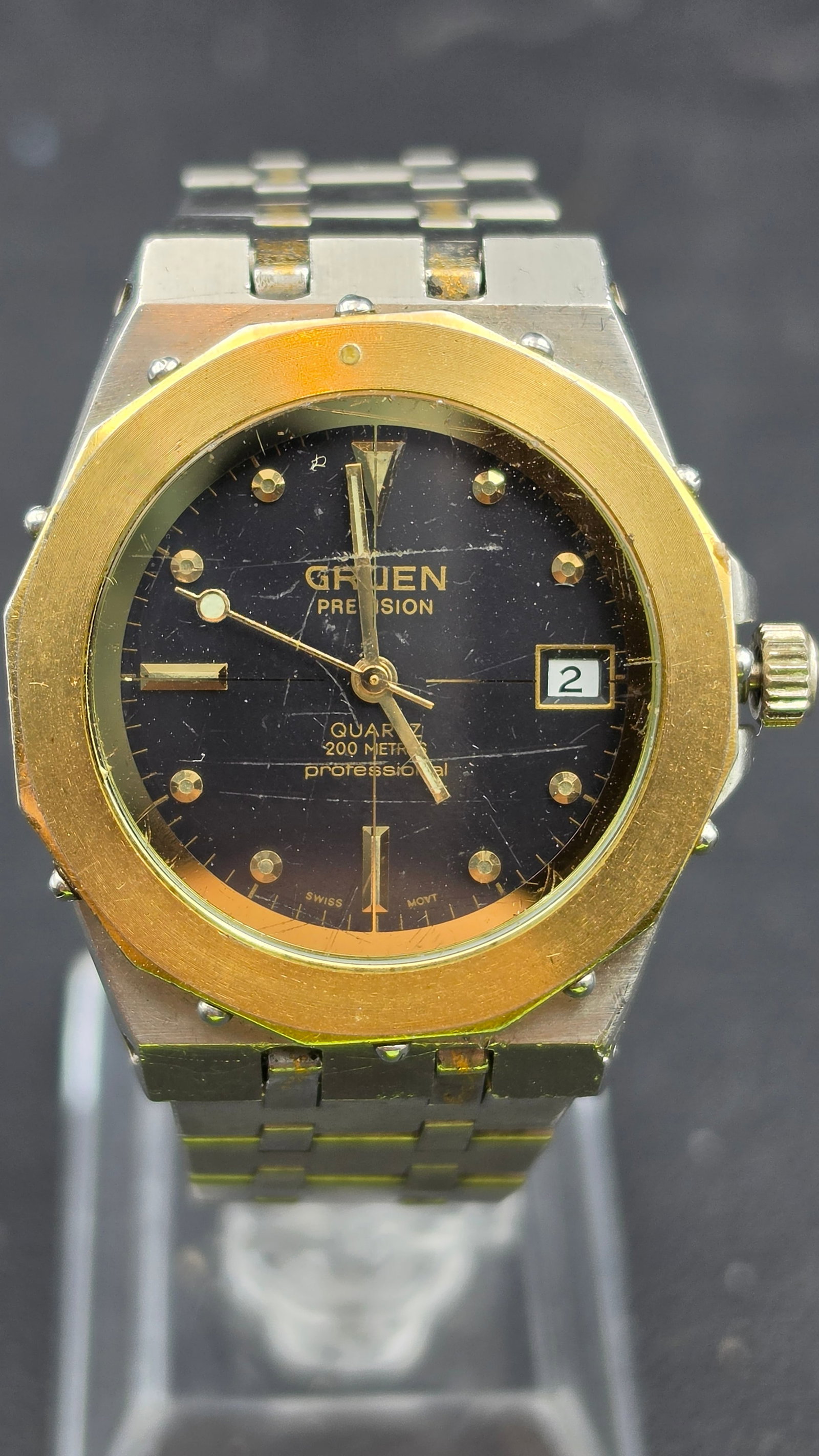 Gruen Precision Quartz 200 Metres Professional Watch Octagonal Bezel: A Gruen Precision quartz wristwatch, case width measuring 34.65mm, in a two tone stainless steel and gold tone case with an octagonal bezel featuring exposed screw head accents in a sport luxury style