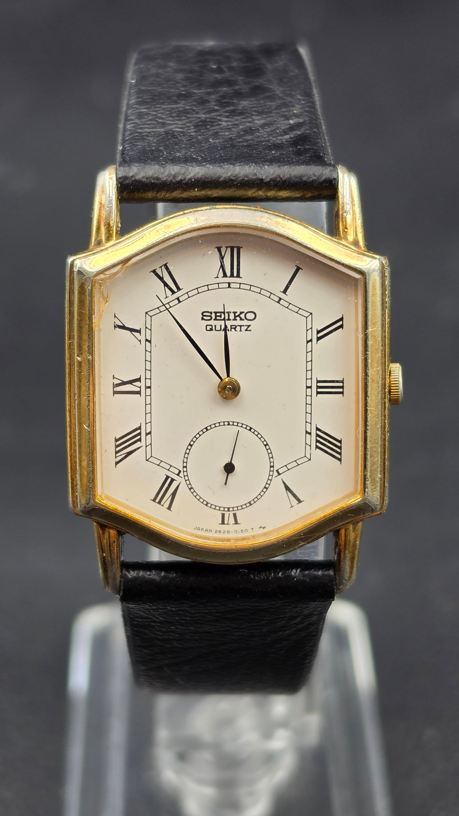 Vintage Seiko Quartz Tank Watch Reference 2628-5039 Roman Numeral Dial Small Seconds Gold Tone Case: This is a vintage Seiko Quartz dress watch, reference 2628-5039, powered by the Seiko caliber 2628 quartz movement, produced in Japan in the early 1980s. The watch has a cushion shaped tank style case