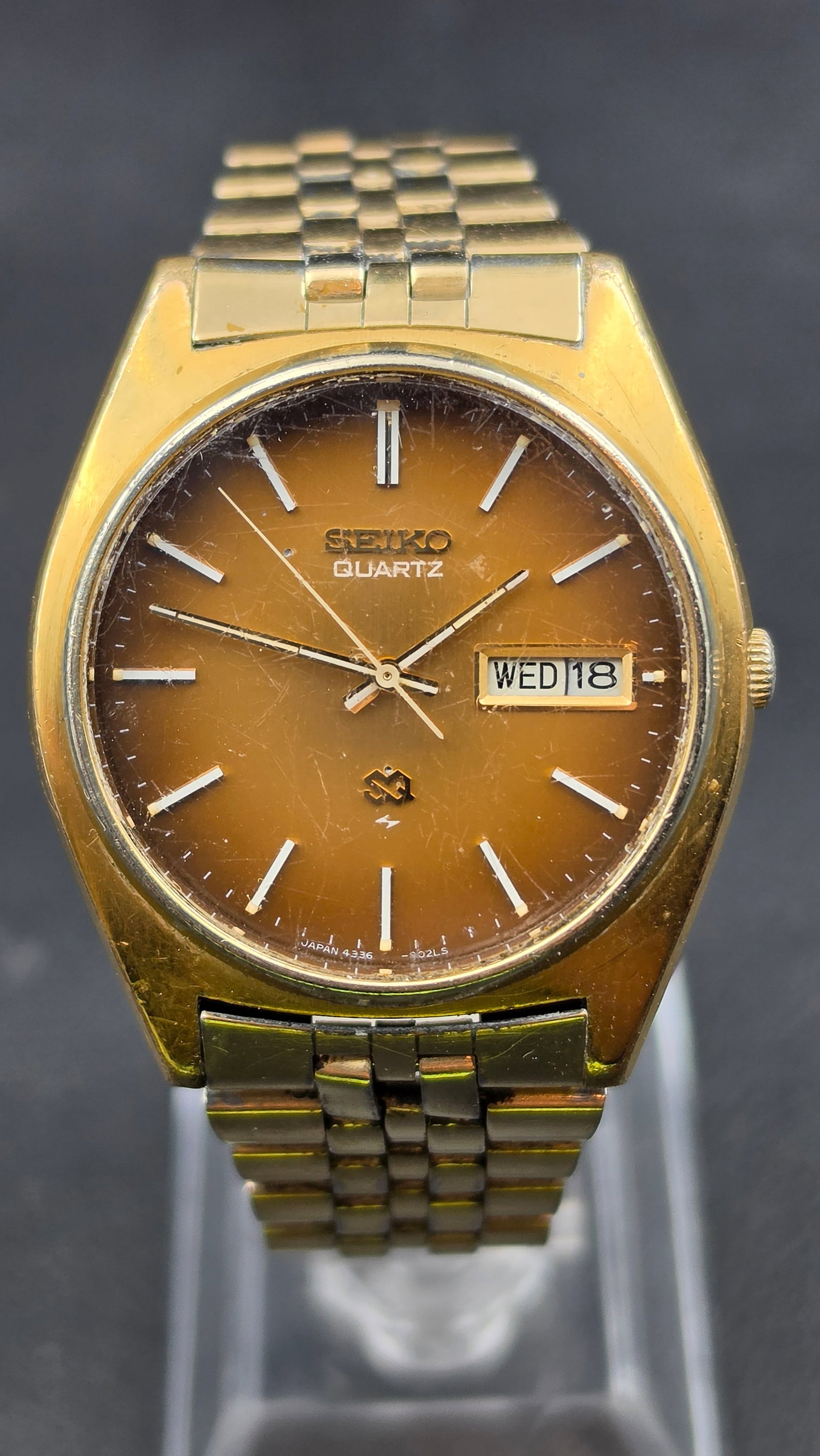 Vintage Seiko Quartz SQ Day Date Gold Tone Watch Reference 4336-8019 Tropical Fade Dial: This is a vintage Seiko Quartz watch, reference 4336-8019. The dial has faded from its original tone into a distinctive brown and gold "tropical" sunburst, a known characteristic of this reference amo