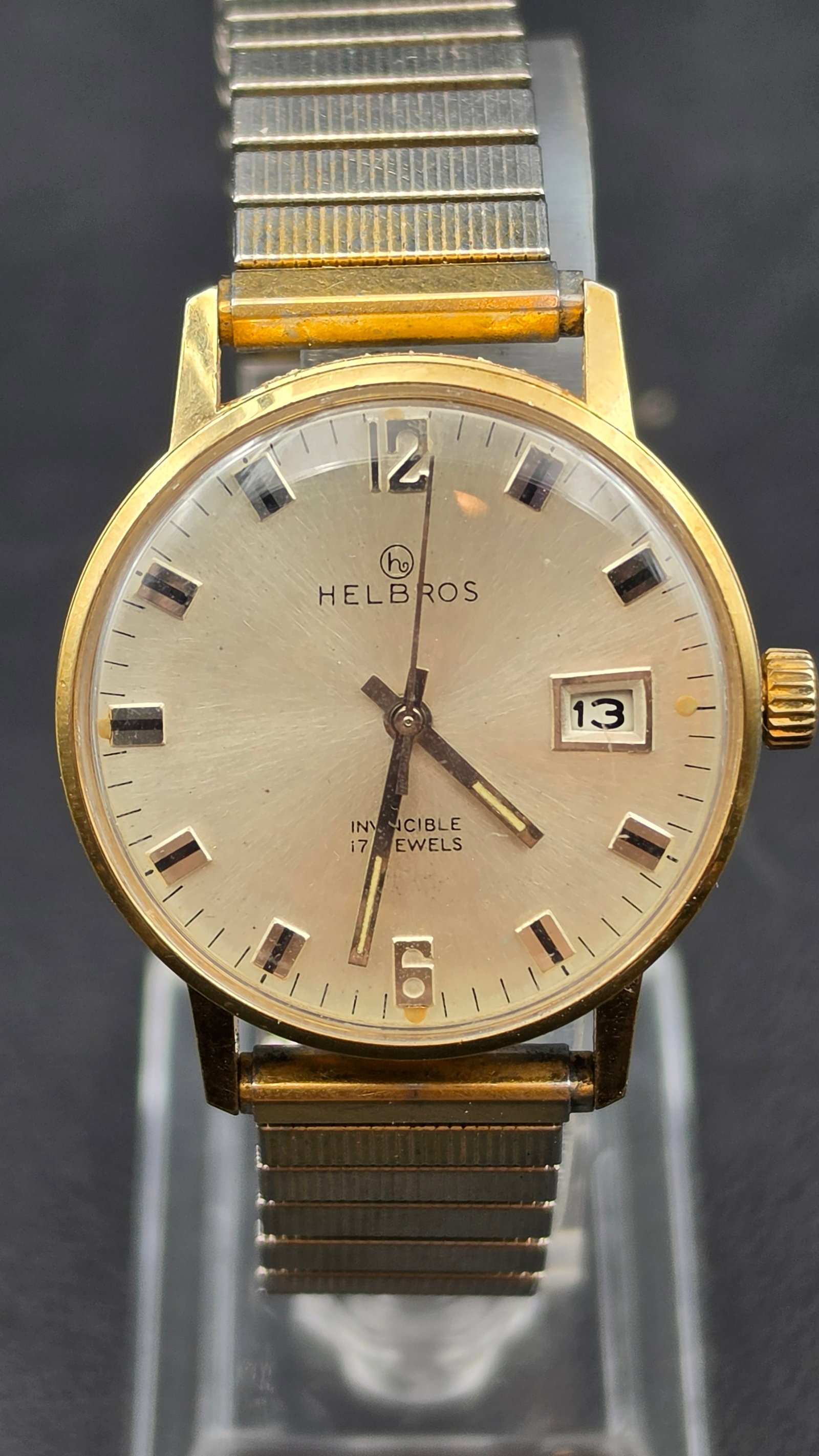 Vintage Helbros Invincible Wristwatch, 17 Jewels, Gold Tone, Date, Running: This is a vintage Helbros Invincible manual-wind wristwatch. Case diameter measures approximately 34mm as verified with digital calipers. The watch is missing its case back, leaving the movement expos
