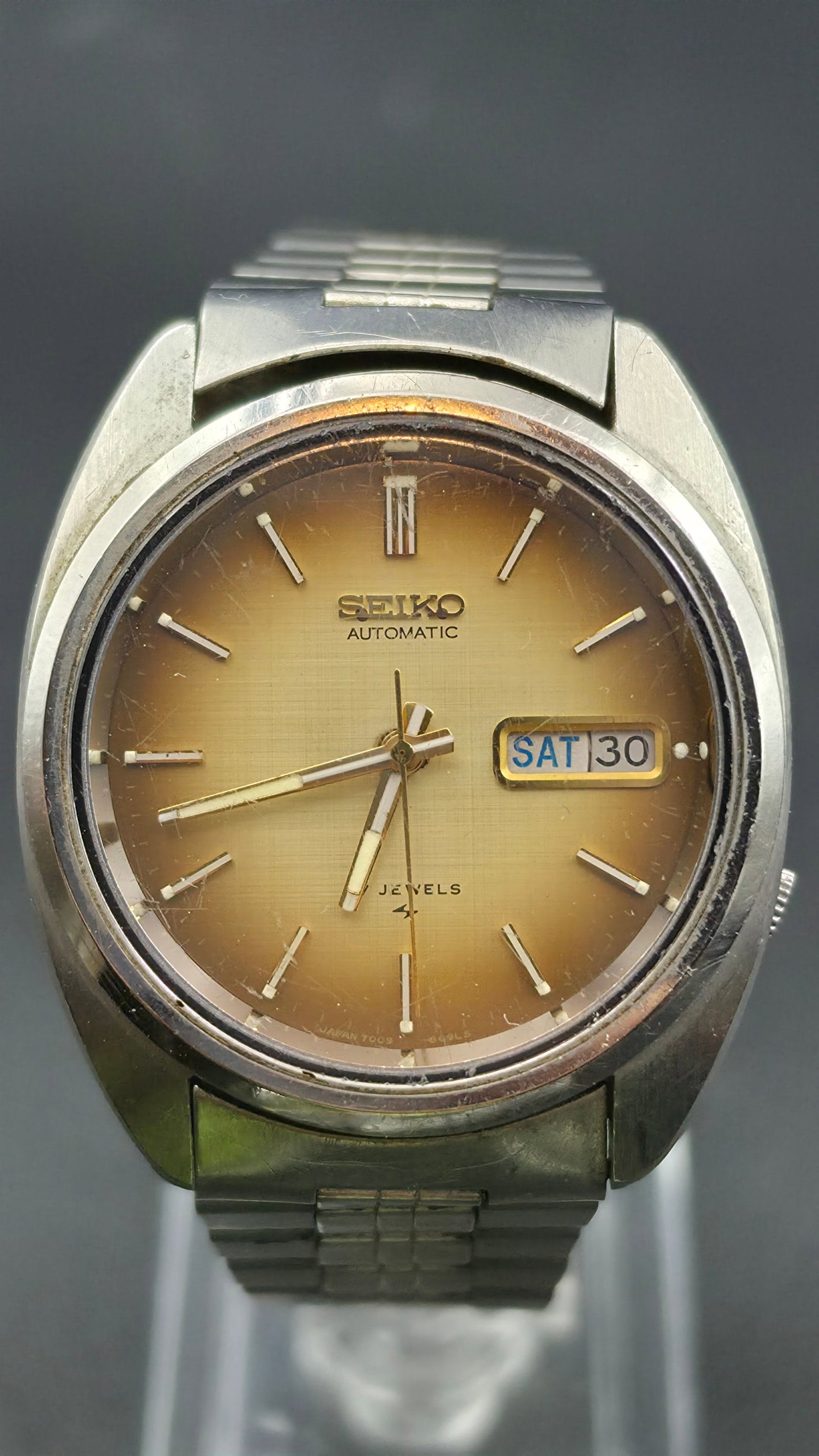 Vintage 1970s Seiko 5 Automatic Day Date Watch 17 Jewels Ref 7009-8089 36mm Tropical Dial: This is a vintage Seiko 5 automatic wristwatch, reference 7009-8089, powered by a self winding Seiko caliber 7009 movement with 17 jewels. The stainless steel case measures approximately 36.5mm across