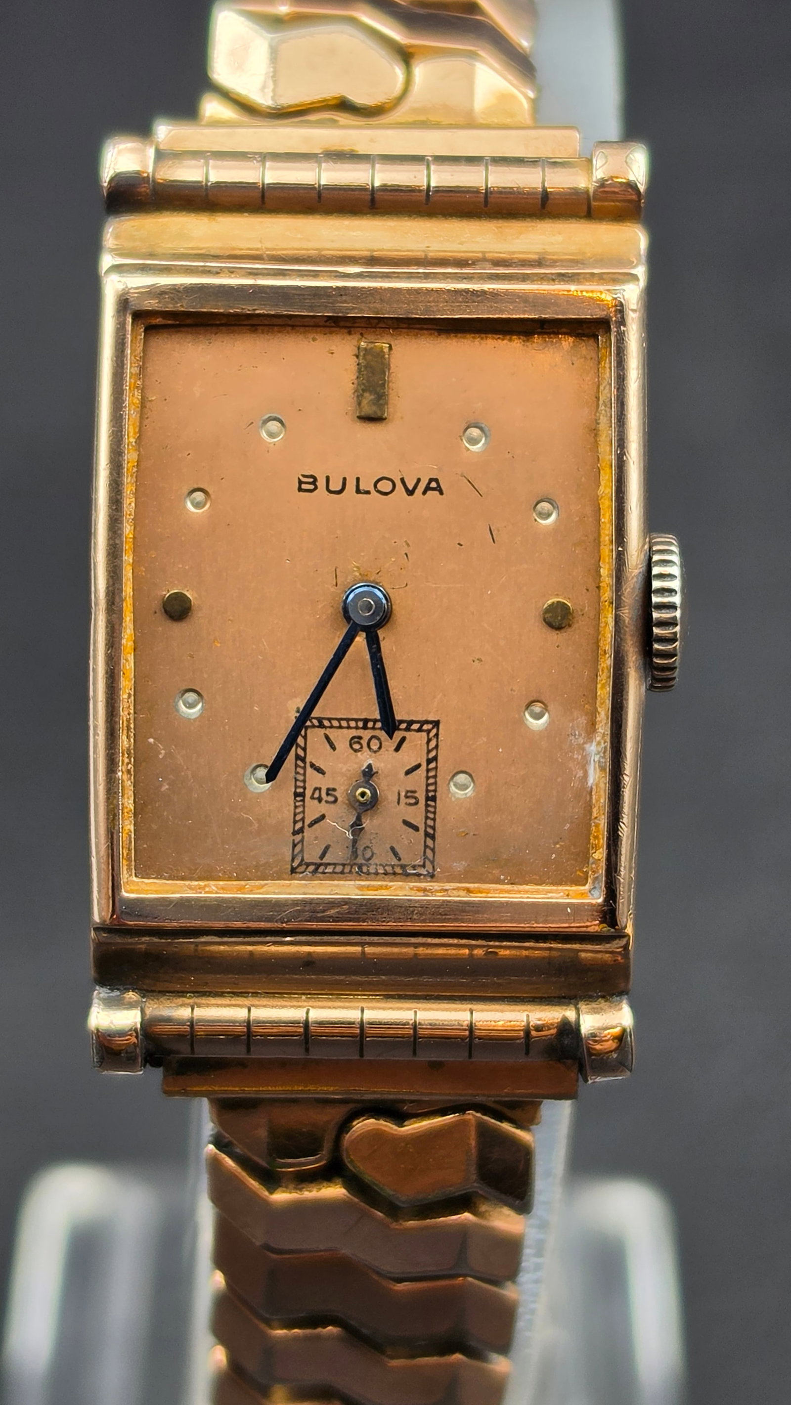 Bulova Art Deco 14K Rose Gold Filled Ladies Watch Caliber 7AP 17 Jewels: This is a vintage Bulova Art Deco style ladies wristwatch with a rectangular 14K rose gold filled tank case on a Speidel Golden Knight expansion bracelet. The salmon dial is signed Bulova, with a step