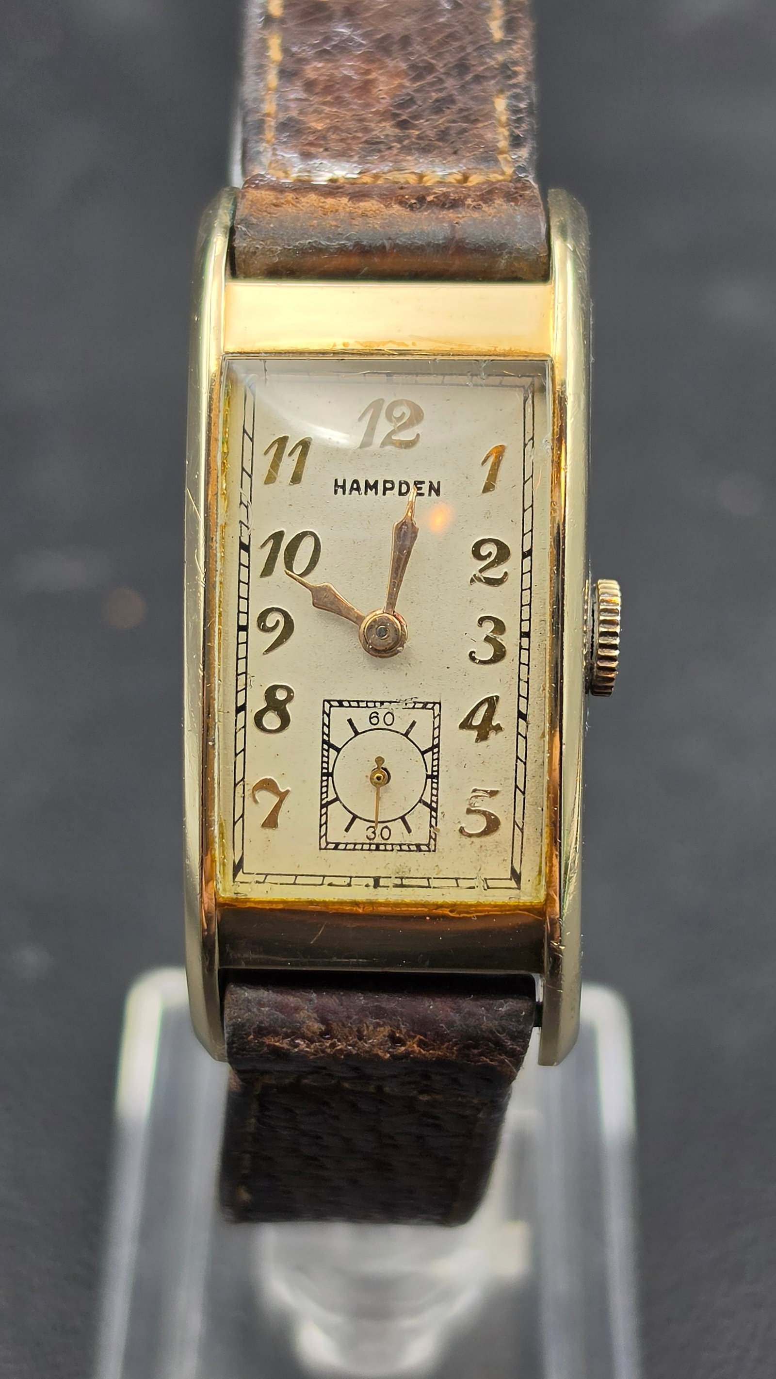 1930s Hampden Swiss Made 17 Jewel 10K Gold Filled Art Deco Tank Wristwatch: This is a Hampden wristwatch with a rectangular Art Deco tank case, signed Hampden on the dial with Arabic numerals and a sub-seconds register at 6 o'clock. The movement is signed Hampden Watch Co., 1