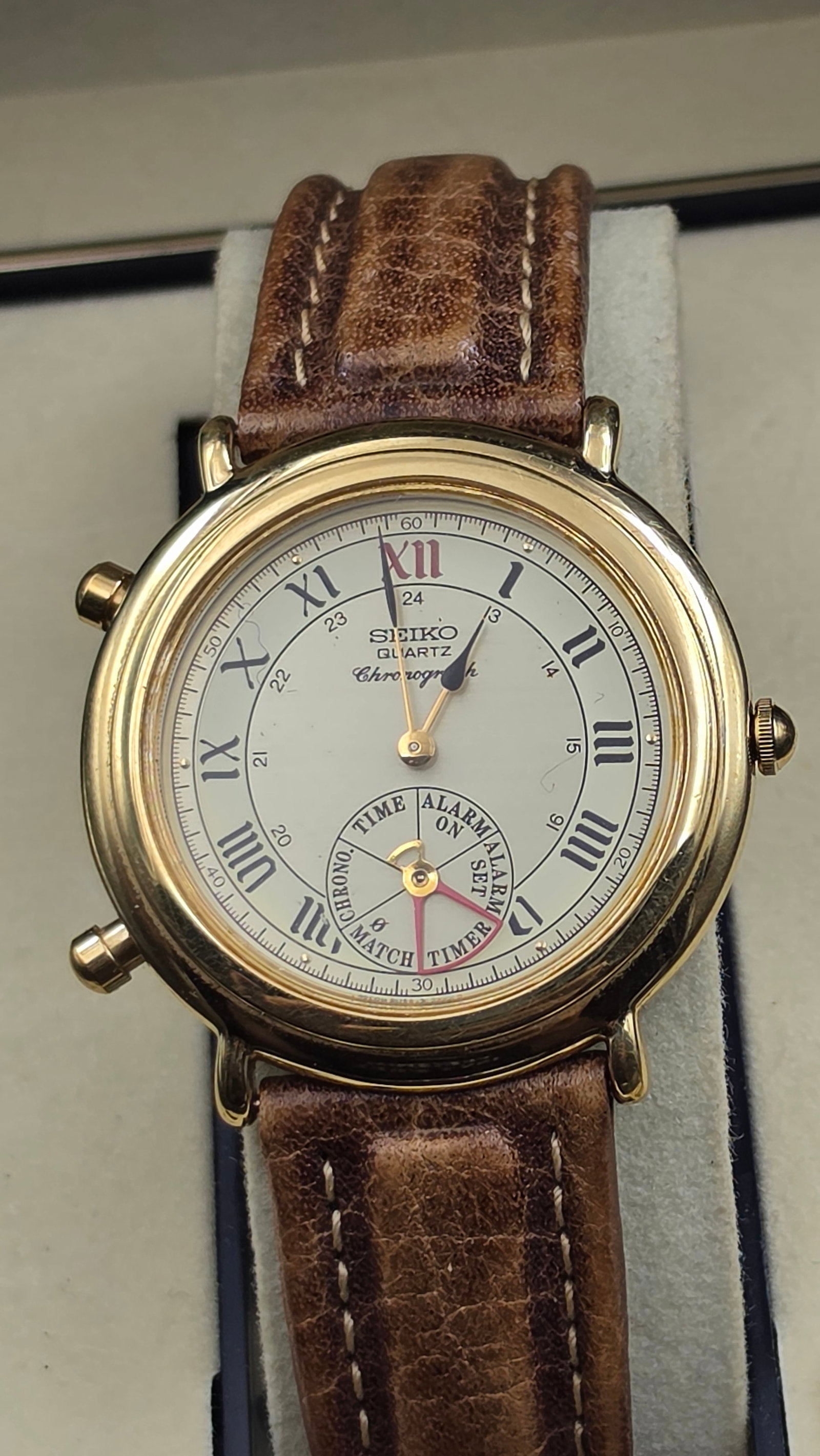 Seiko Quartz Chronograph Alarm Cal 7T32 Roman Numeral Watch 1990s: This is a Seiko Quartz Chronograph with alarm function, dial signed Seiko Quartz Chronograph with black Roman numeral hour markers and a 24 hour inner track. The sub-dial offers Chrono, Time, Alarm On