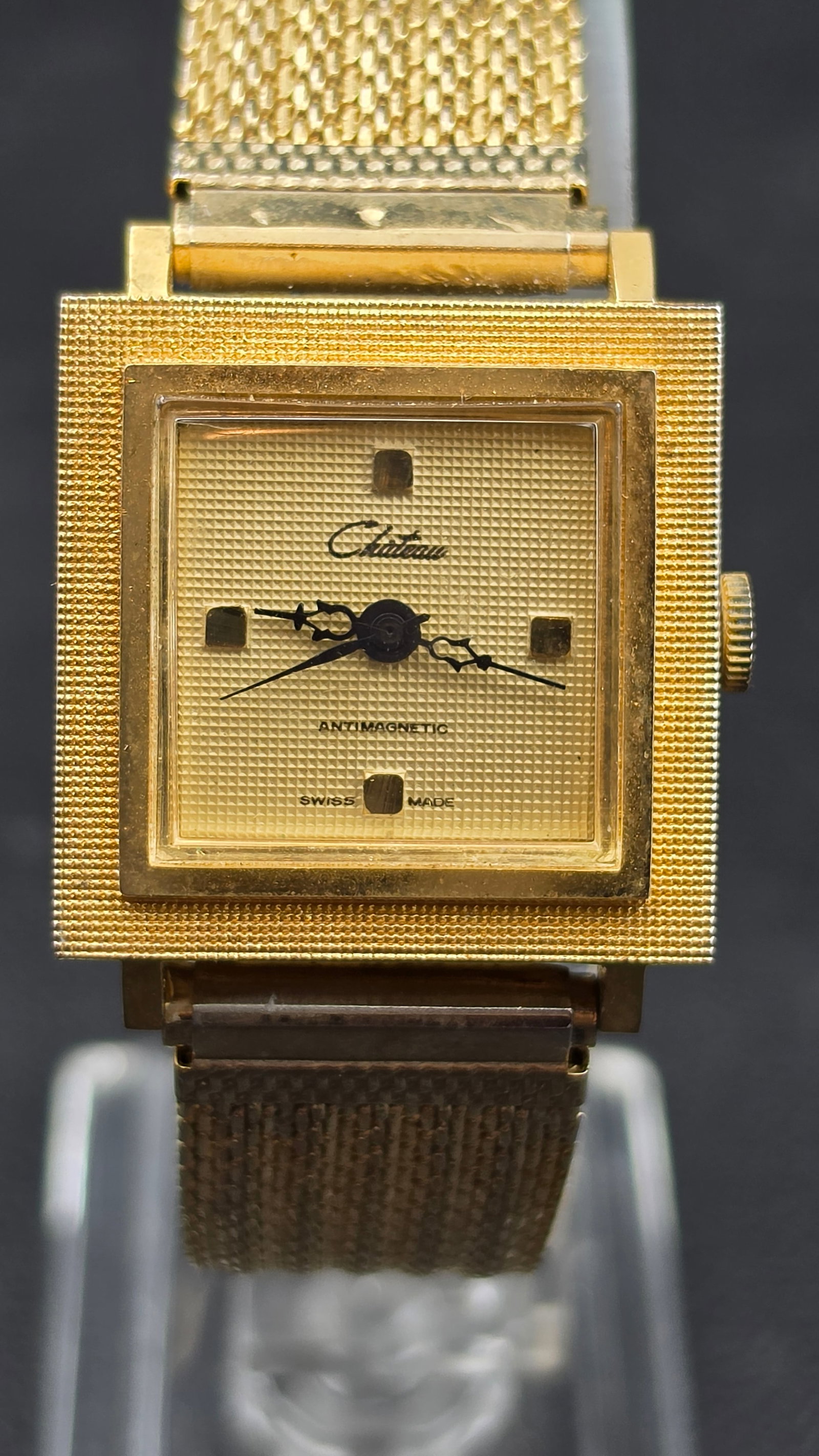 Chateau Antimagnetic Swiss Made Square Manual Wind Watch Mesh Bracelet: This is a Chateau manual wind watch with a square case, textured gold tone dial signed Chateau Antimagnetic Swiss Made, and a matching gold tone mesh bracelet. The case back is stamped Base Metal Swis