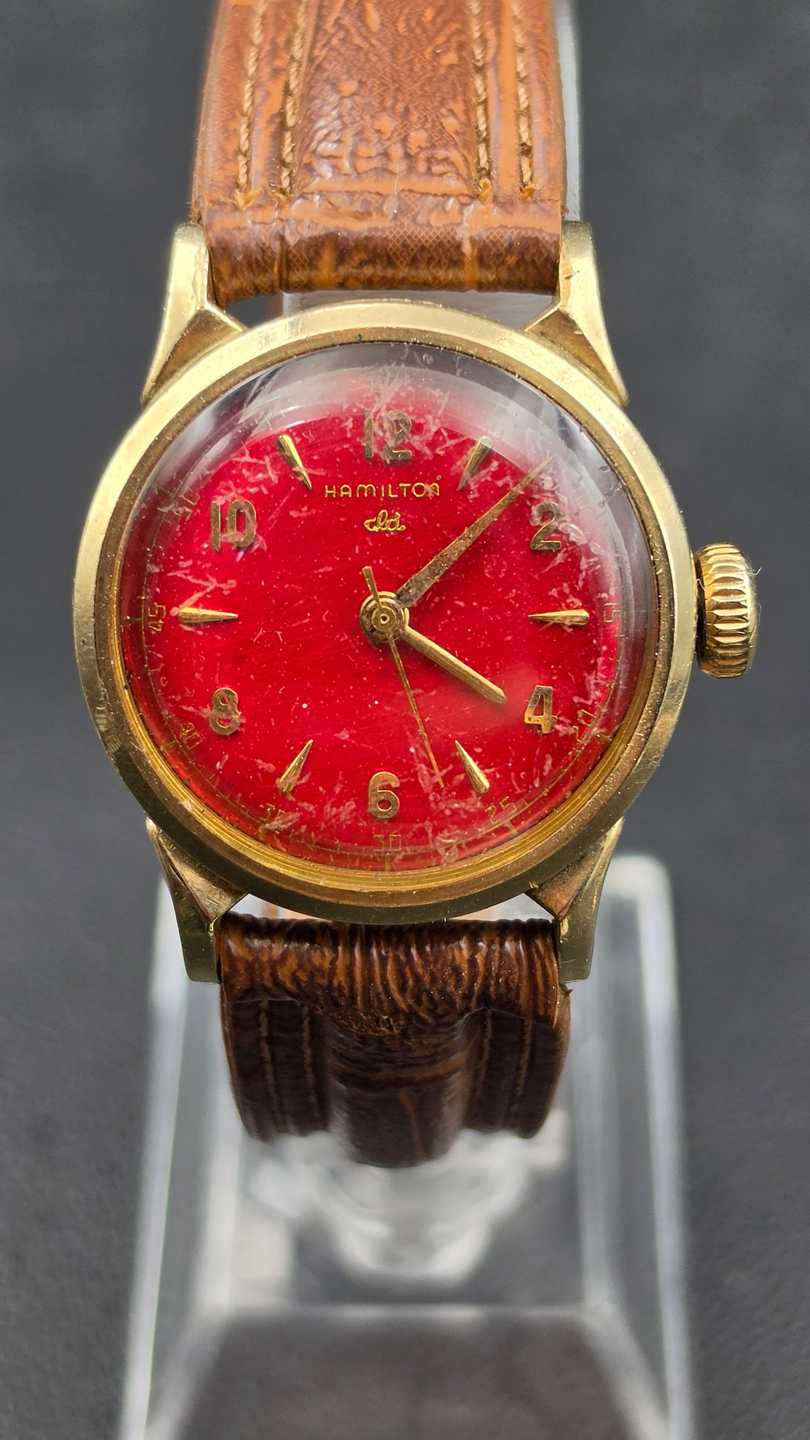 Vintage Hamilton 18 Jewel Watch, 10K Gold Filled Case, Red Dial, Cal. 748: This vintage manual wind wristwatch is signed Hamilton on a red dial with gold tone Arabic numerals and dagger markers. The case measures approximately 29.2mm in diameter and the case back is marked H
