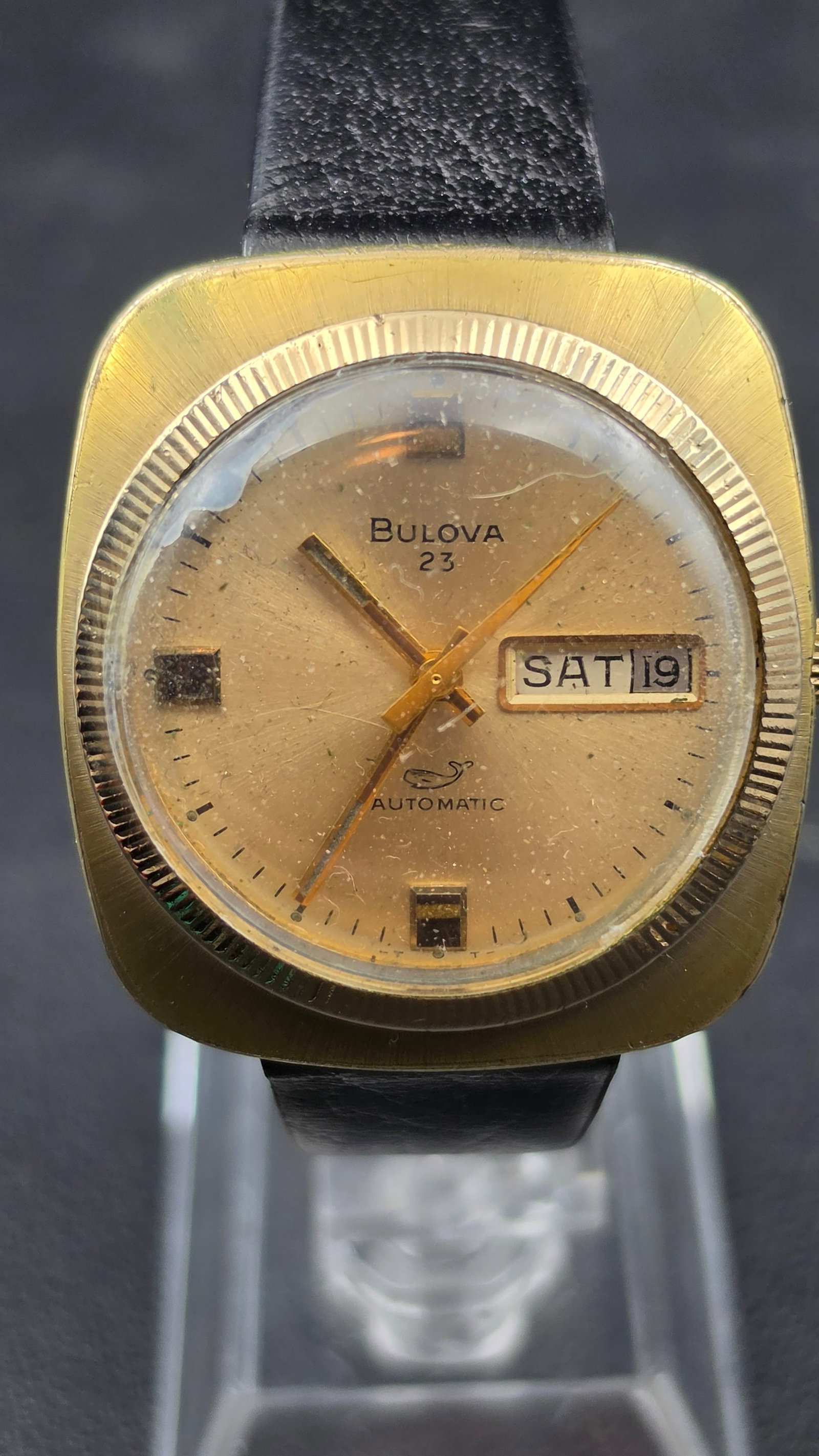Vintage 1972 Bulova 23 Jewel Automatic Day Date 11AOACB Gold Electroplate Running: This vintage Bulova automatic wristwatch is signed Bulova 23 on the dial with day and date windows, and powered by the caliber 11AOACB movement, marked Bulova Watch Co., 23 Twentythree Jewels, and N2.