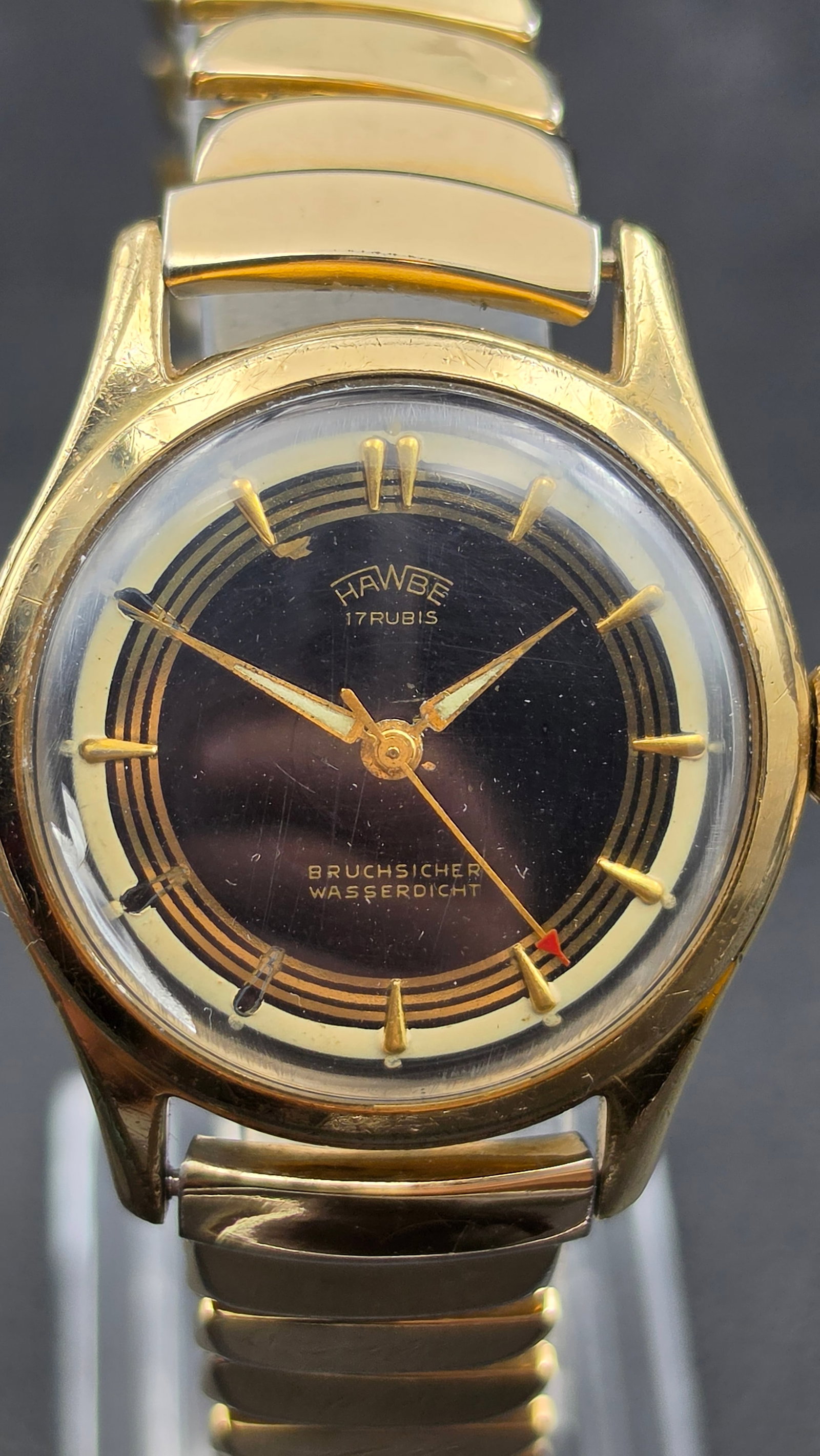 Vintage HAWBE 17 Rubis German Wristwatch Bruchsicher Wasserdicht Gold Plated Running: This vintage wristwatch is signed HAWBE and 17 Rubis on the dial, along with Bruchsicher (shockproof) and Wasserdicht (waterproof), a German-made piece produced by H.F. Bauer of Pforzheim. The black a